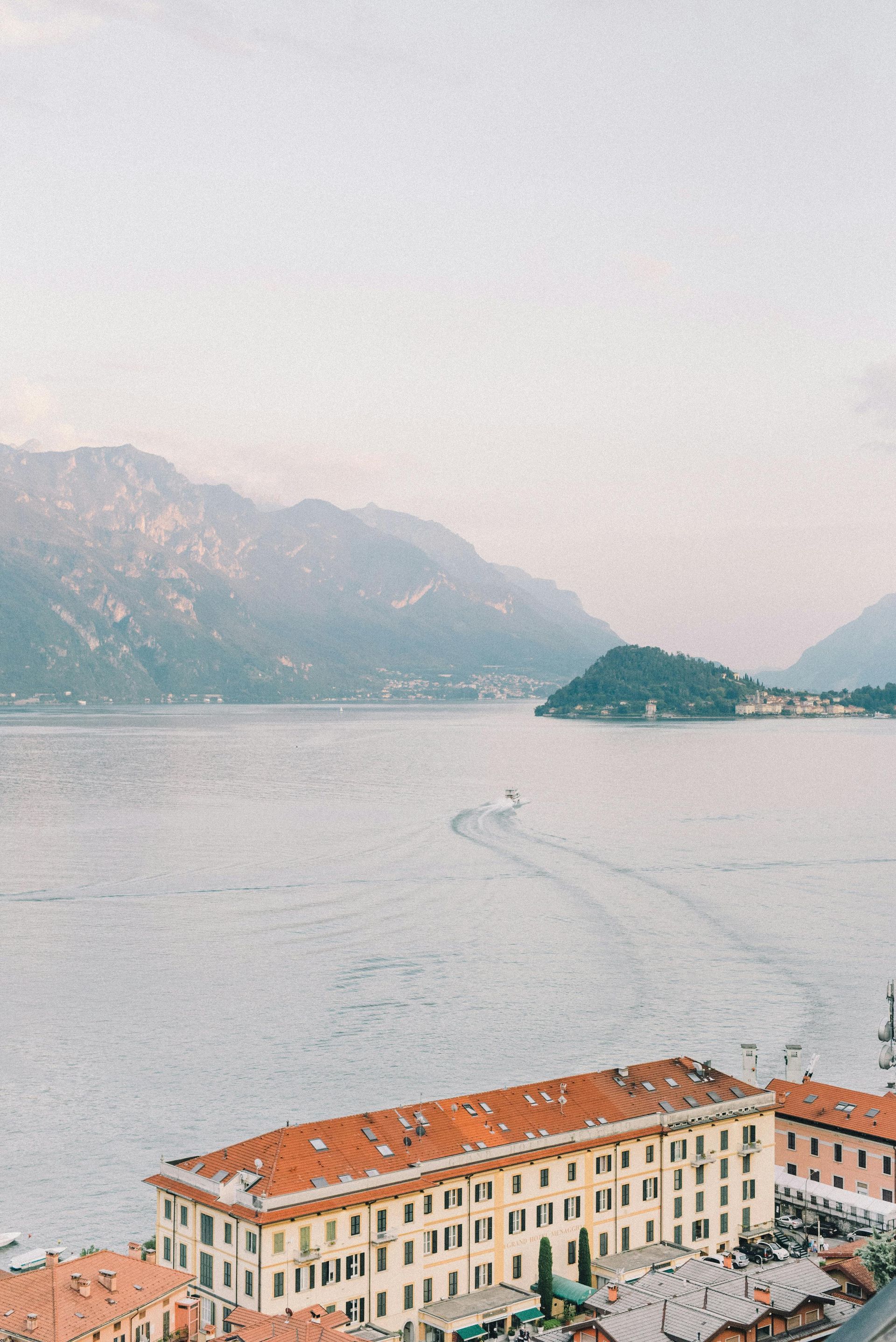 An aerial view of a city overlooking Lake Como with mountains in the background in Italy.