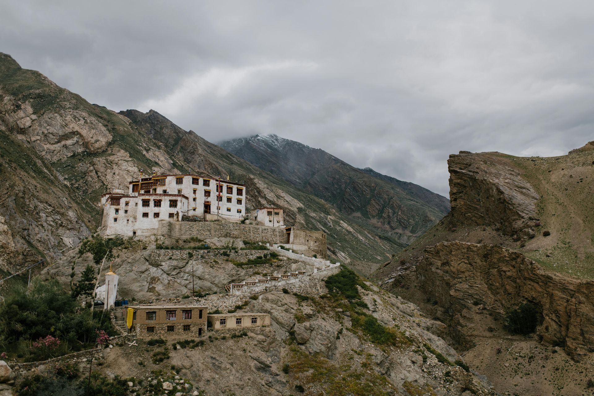 A castle is sitting on top of a rocky hill surrounded by mountains in Cusco, Peru.