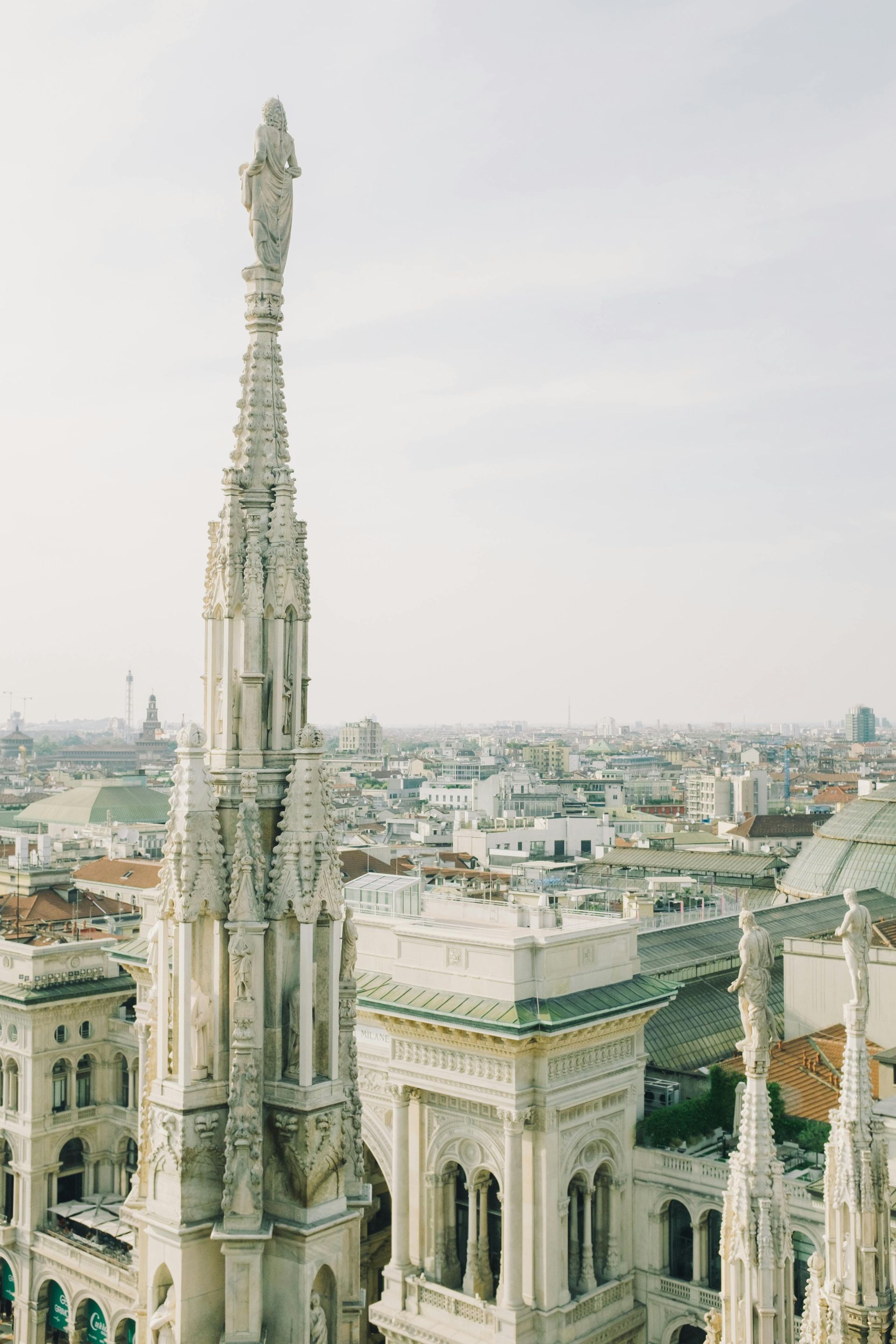 An aerial view of Milan, Italy with a very tall building in the foreground.