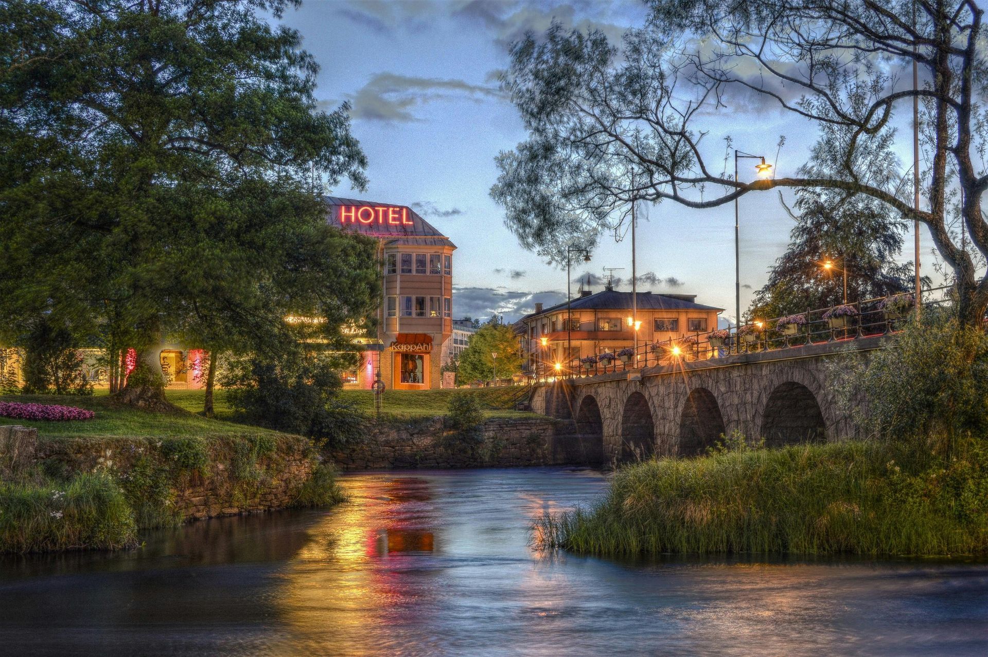 A bridge over a river with a hotel in the background in Sweden.