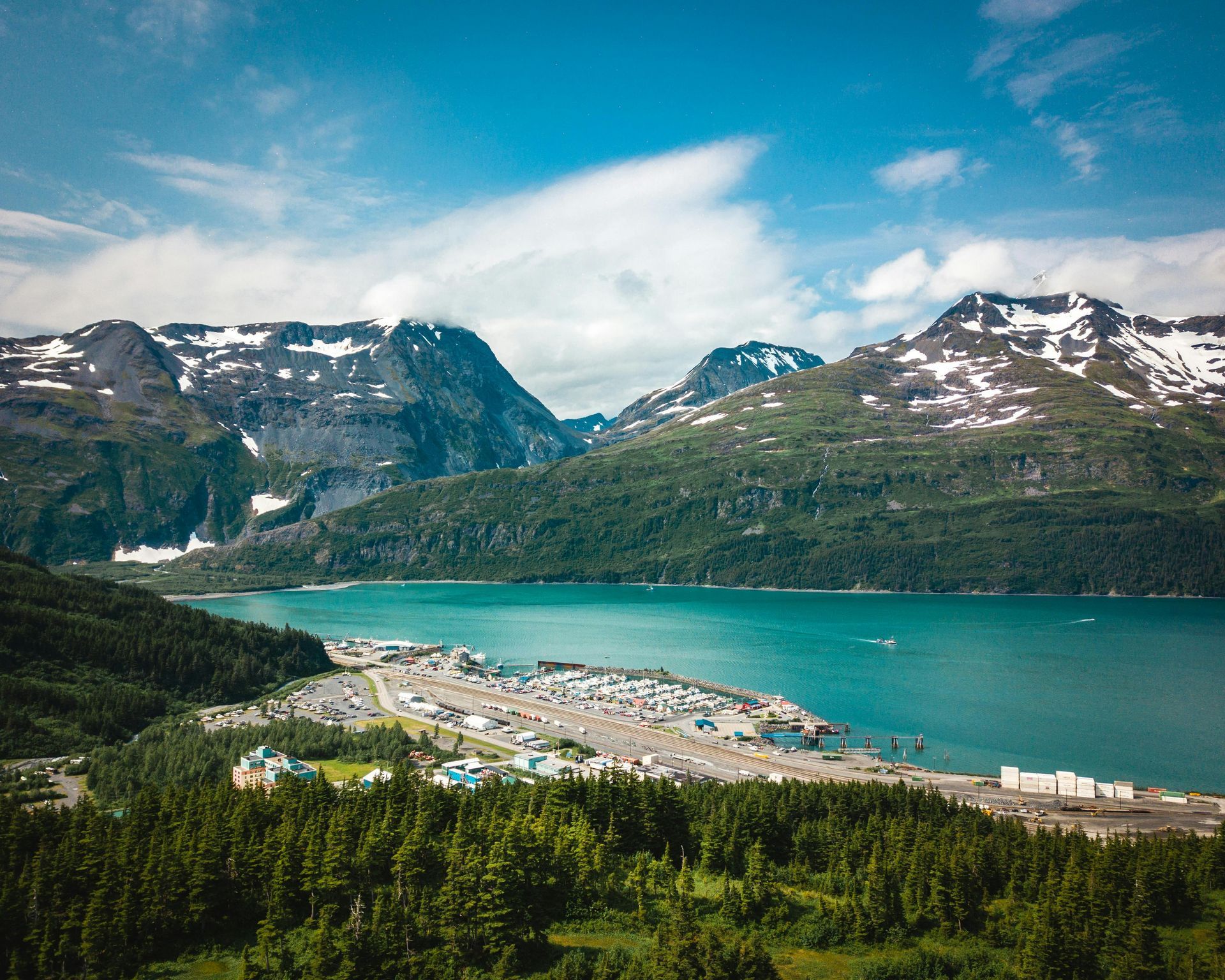 An aerial view of a lake surrounded by mountains and trees at Horsetail Falls in Alaska.