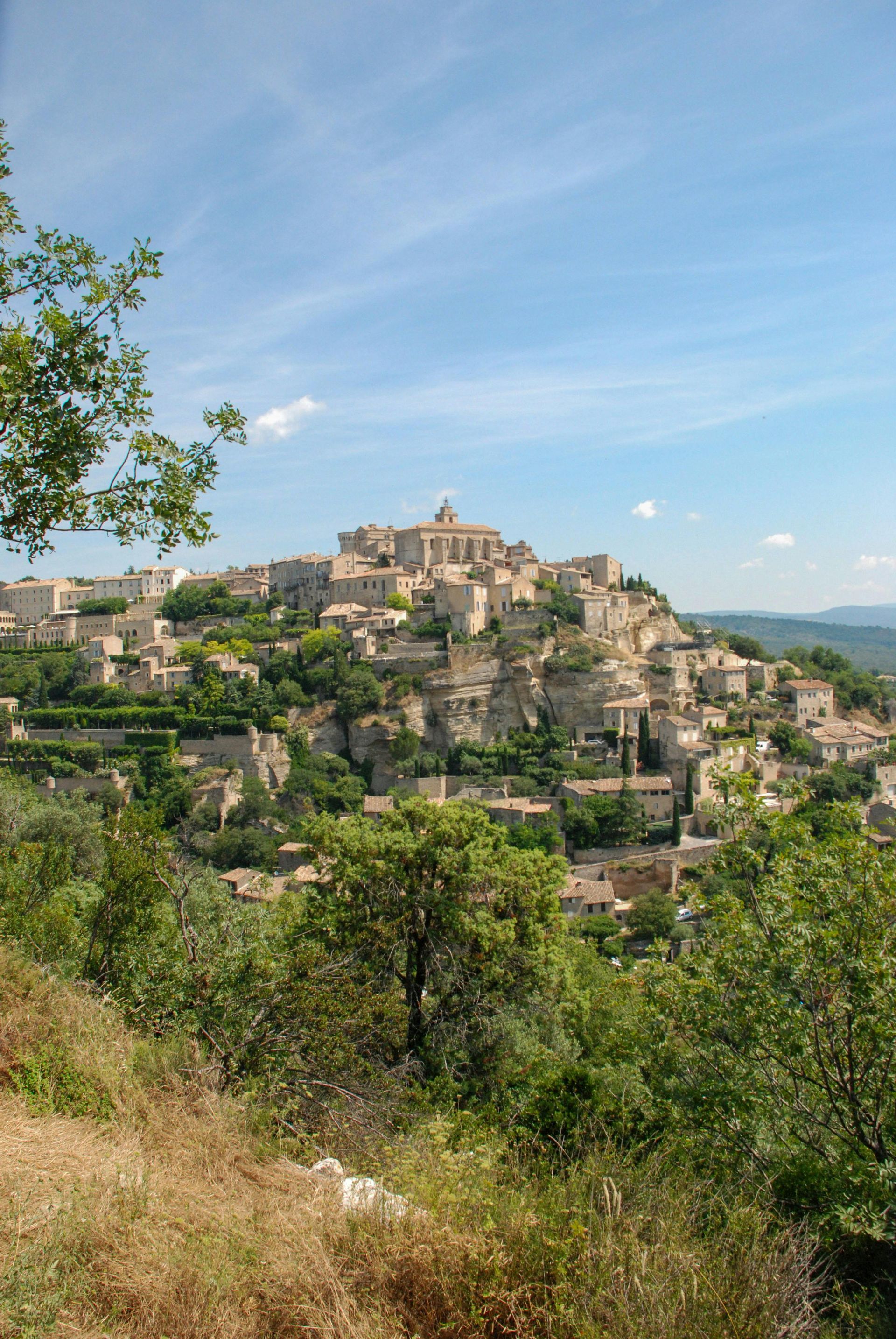 A small town is sitting on top of a hill surrounded by trees in Aix-en-Provence.