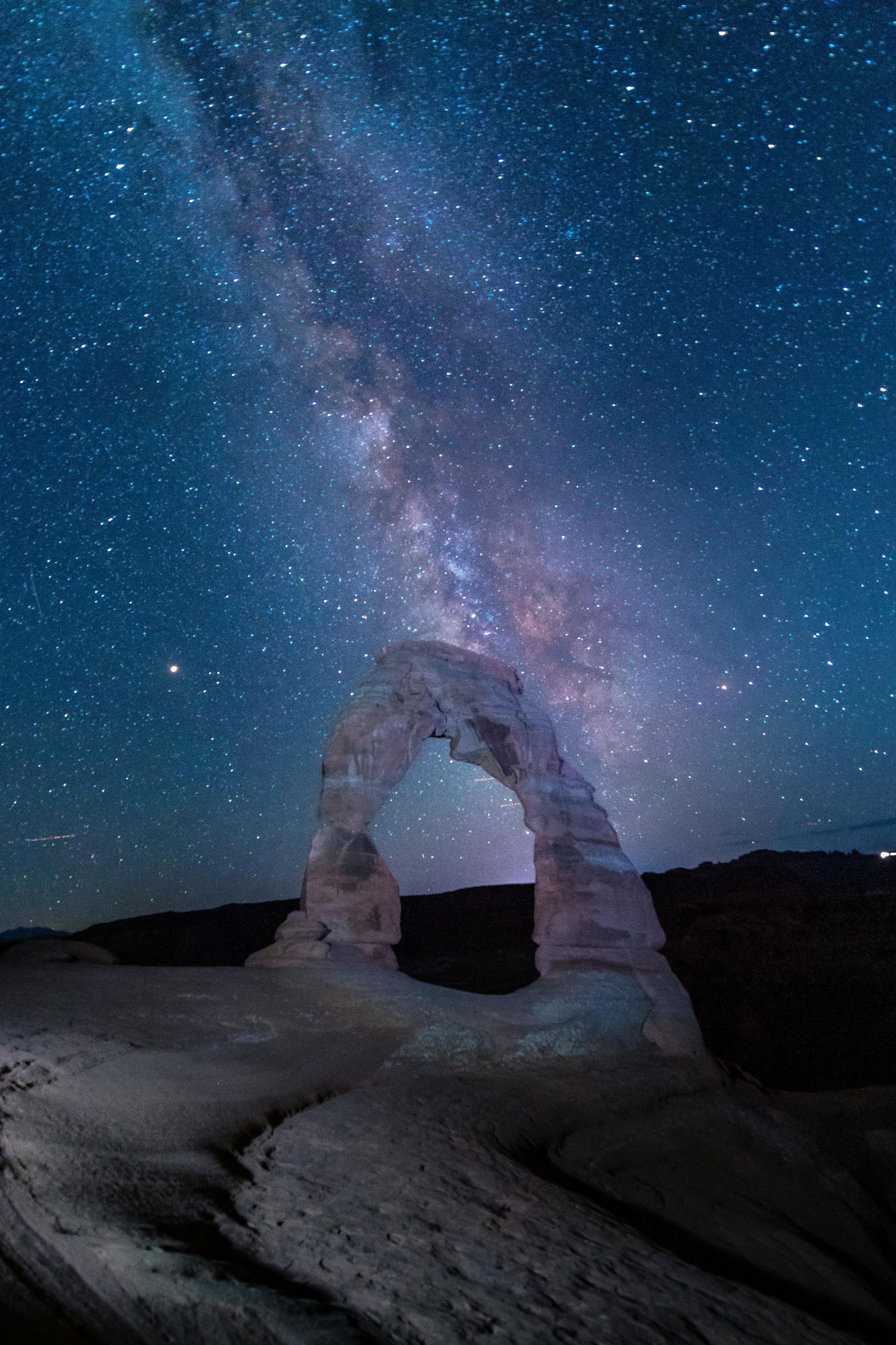 The Delicate Arch under a starry night sky with the milky way visible in Utah.