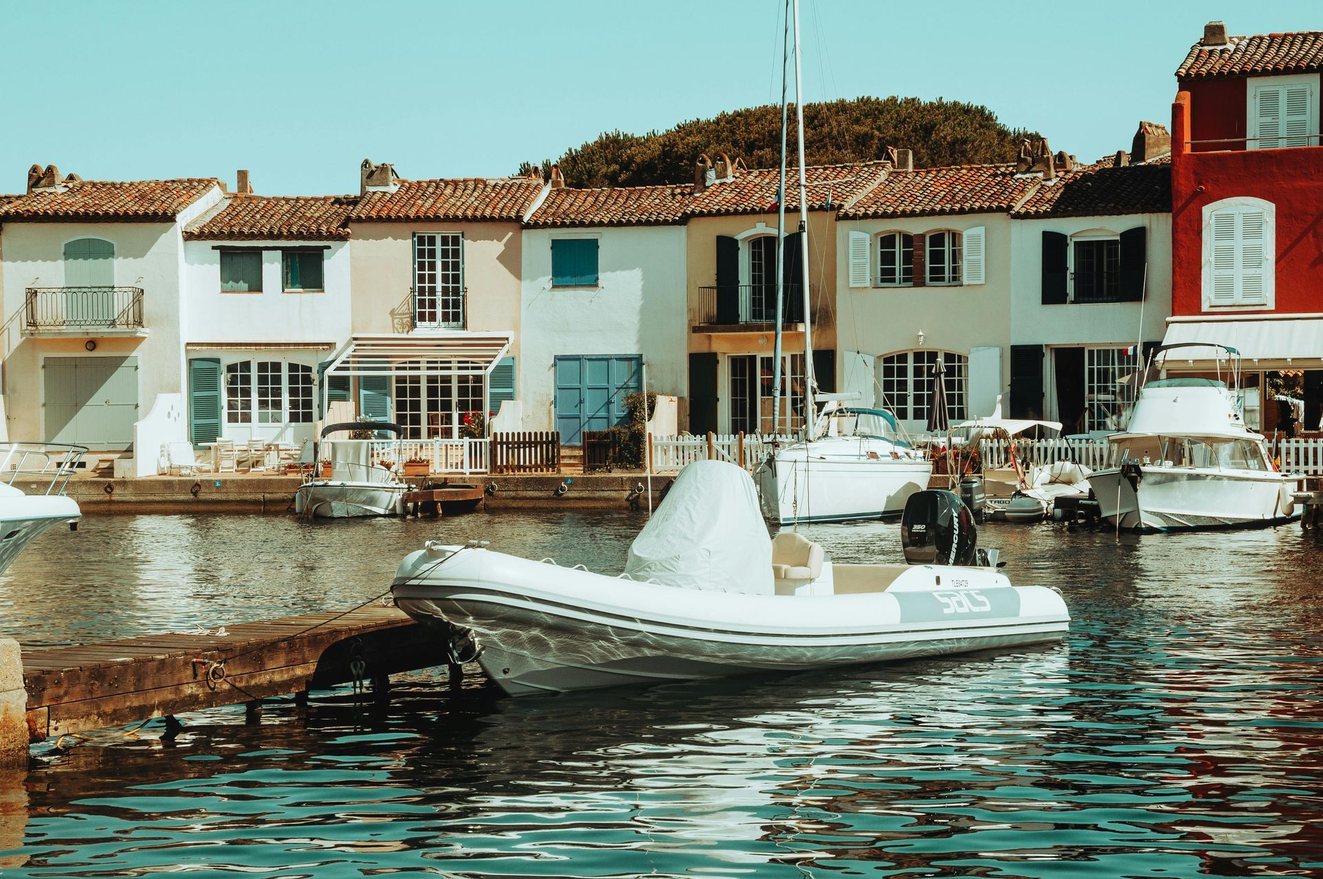 A boat is docked in a harbor with buildings in the background in Côte d’Azur.