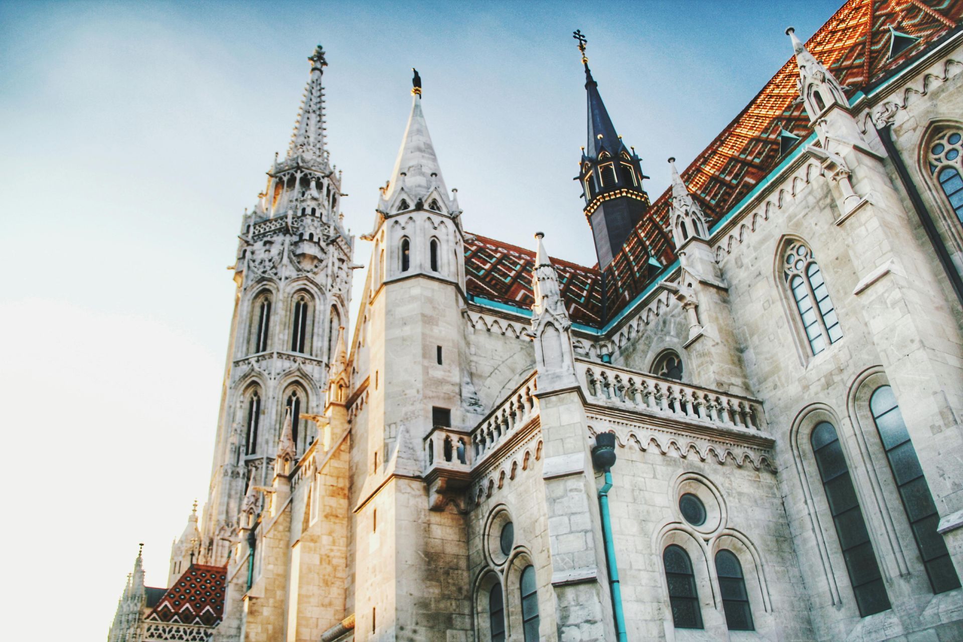 Matthias Church with a red roof and a blue sky in the background in Budapest, Hungary.