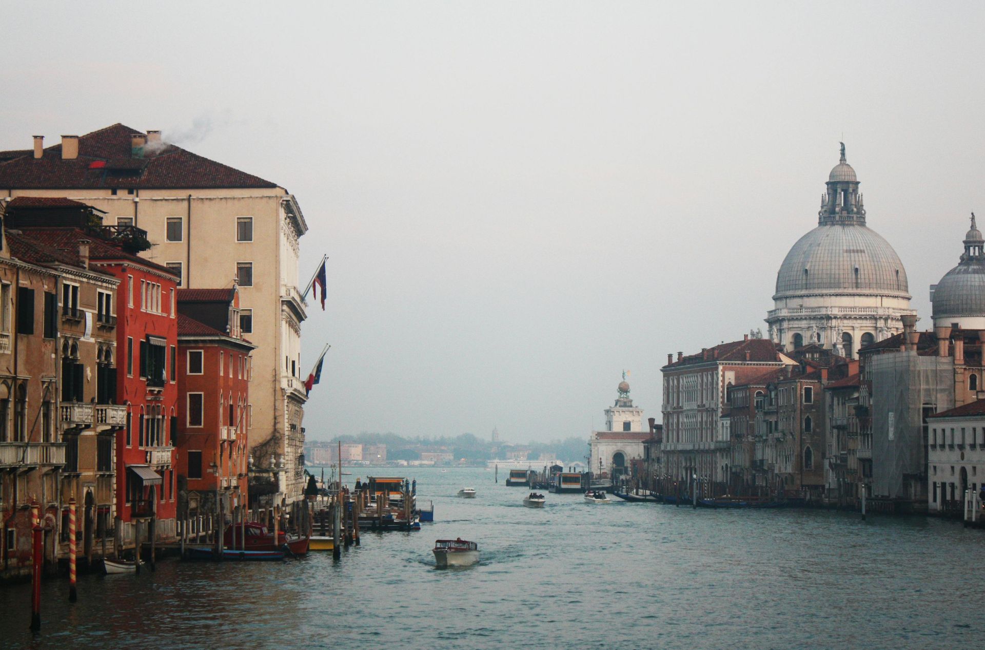 A canal of water surrounded by buildings and a dome in Venice, Italy.