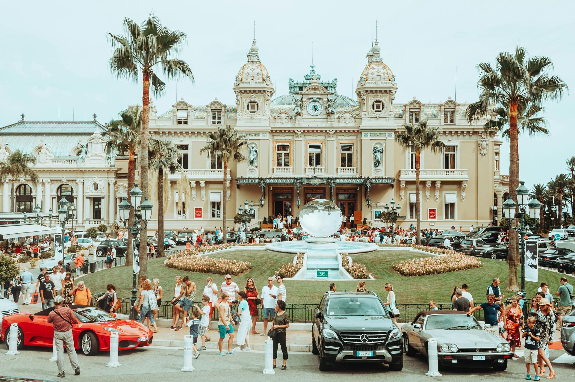 A group of cars are parked in front of a large building in Monaco.