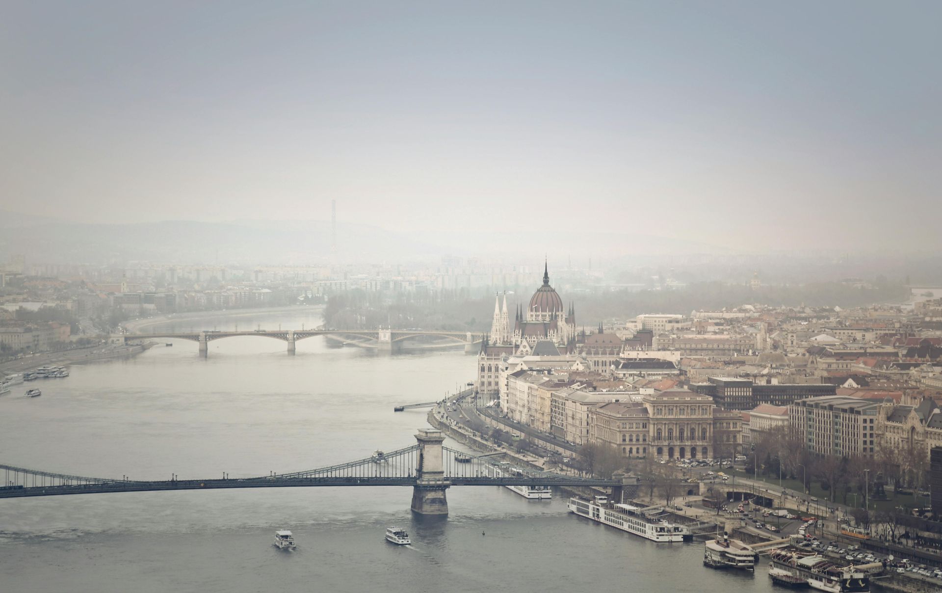 An aerial view of a city with the Széchenyi Chain Bridge over the Danube River in Budapest, Hungary.