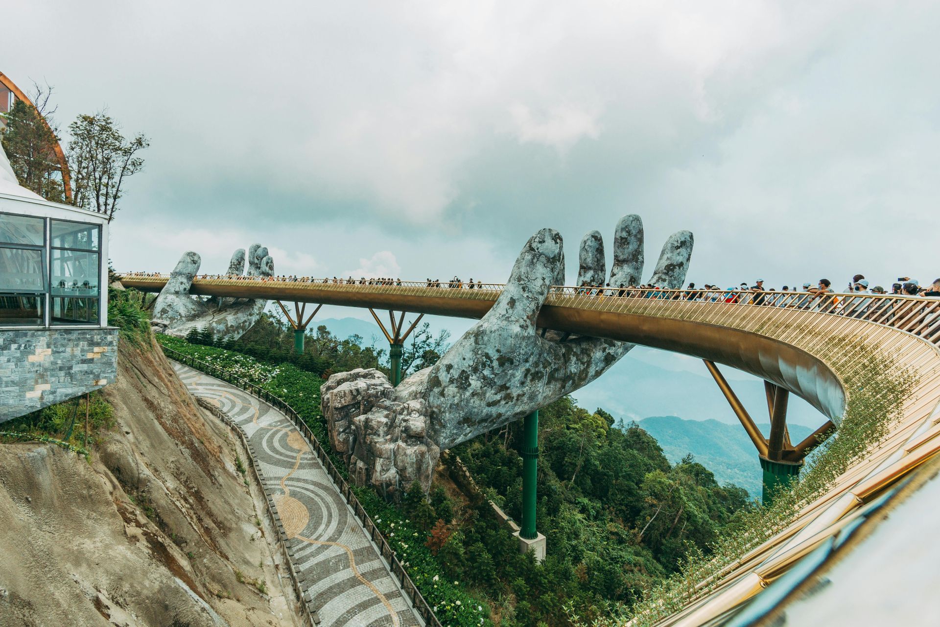 The Golden Bridge on top of a hill held by two stone hands in Vietnam. 