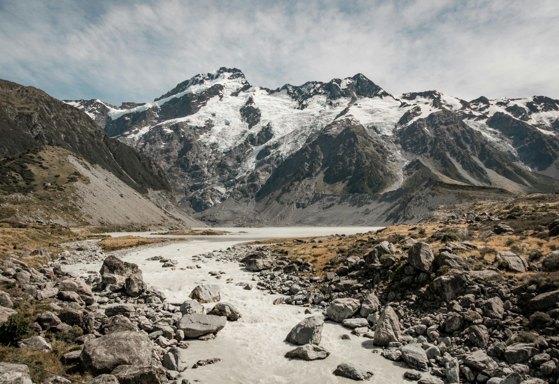 A river flowing through a rocky area with mountains in the background in New Zeland.