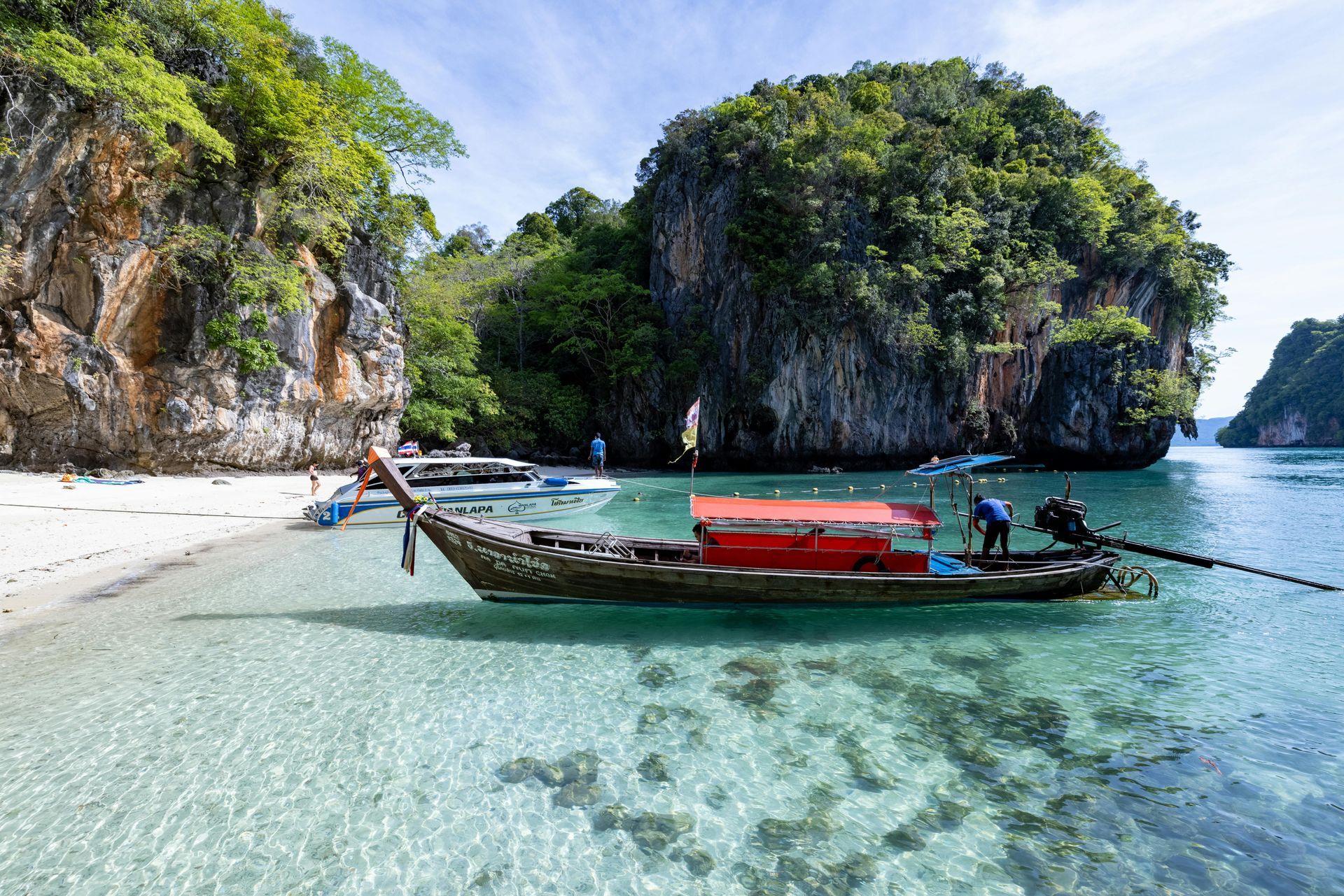 A boat is floating on top of a body of water near a beach in Laos.