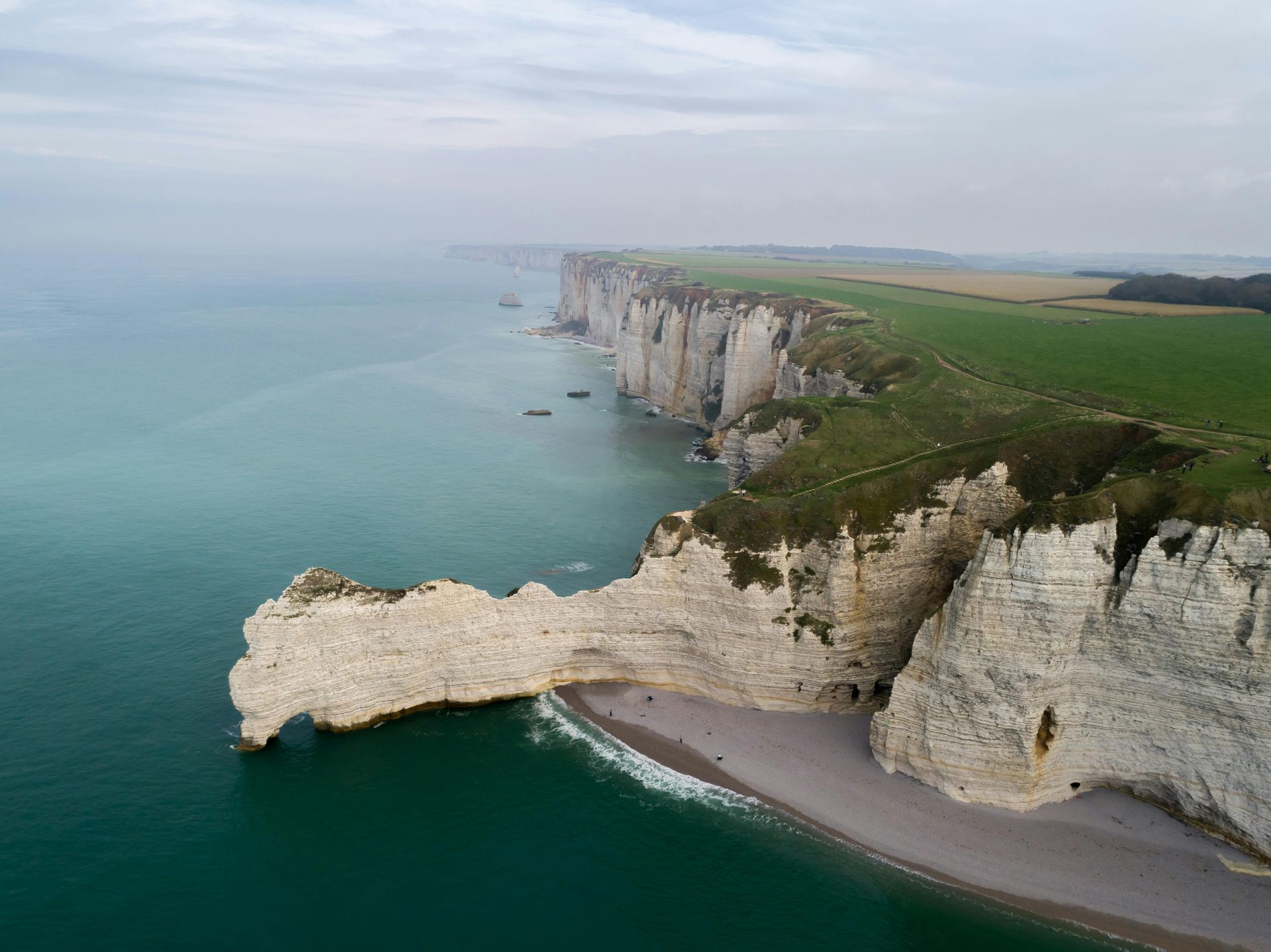 An aerial view of the cliff Étretat overlooking the ocean in Normandy, France.