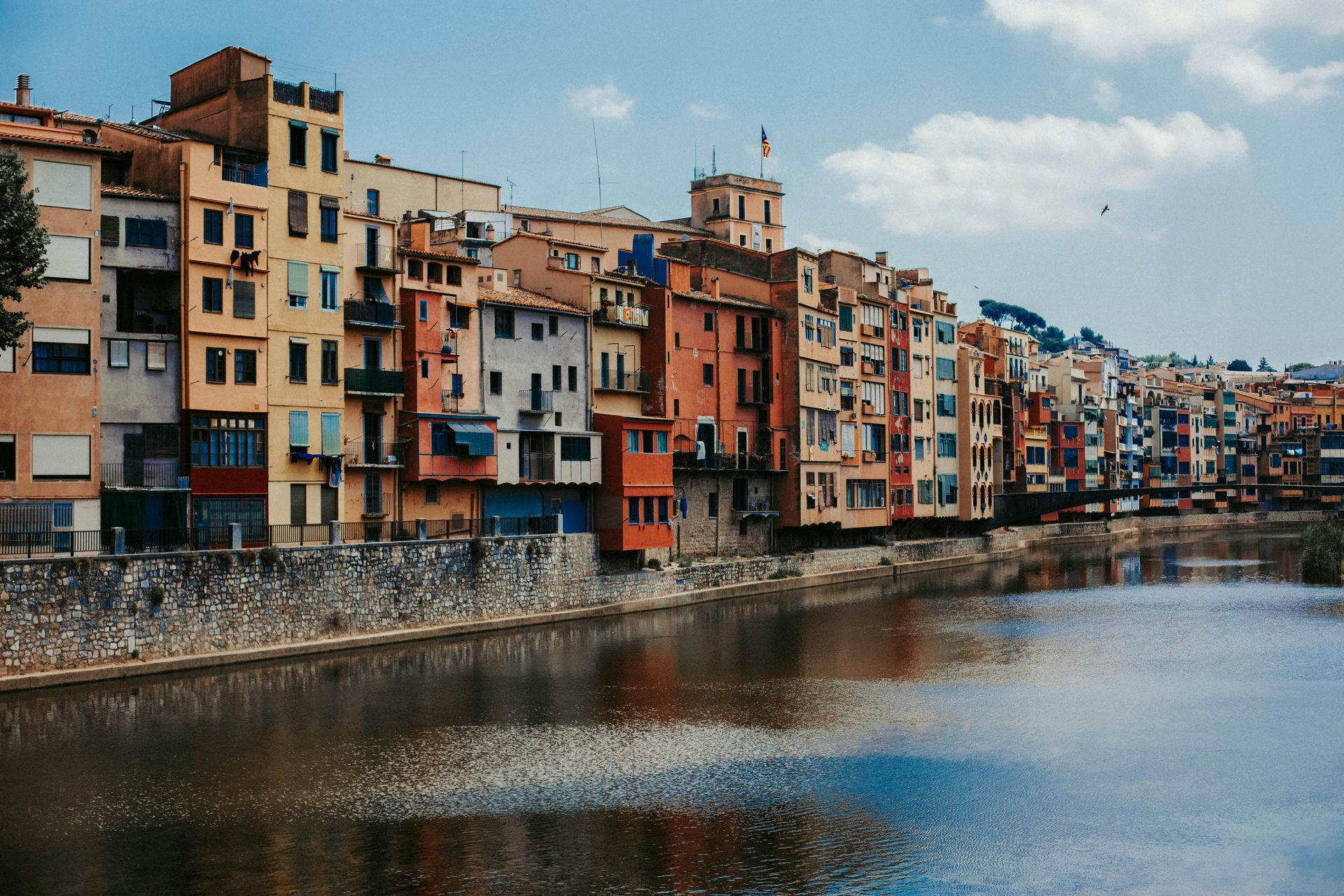 A row of buildings next to a body of water in Girona, Spain.