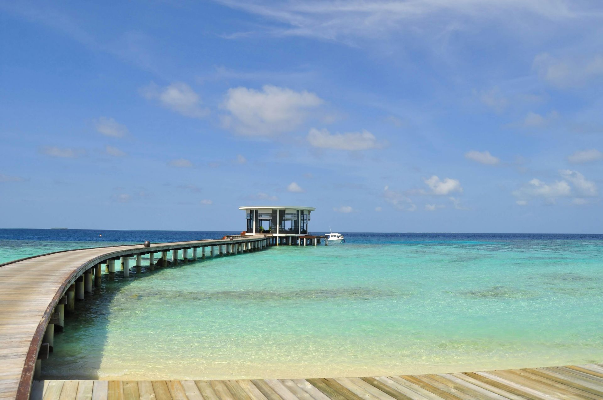 A wooden pier leading into the ocean on a sunny day in the Caribbean.