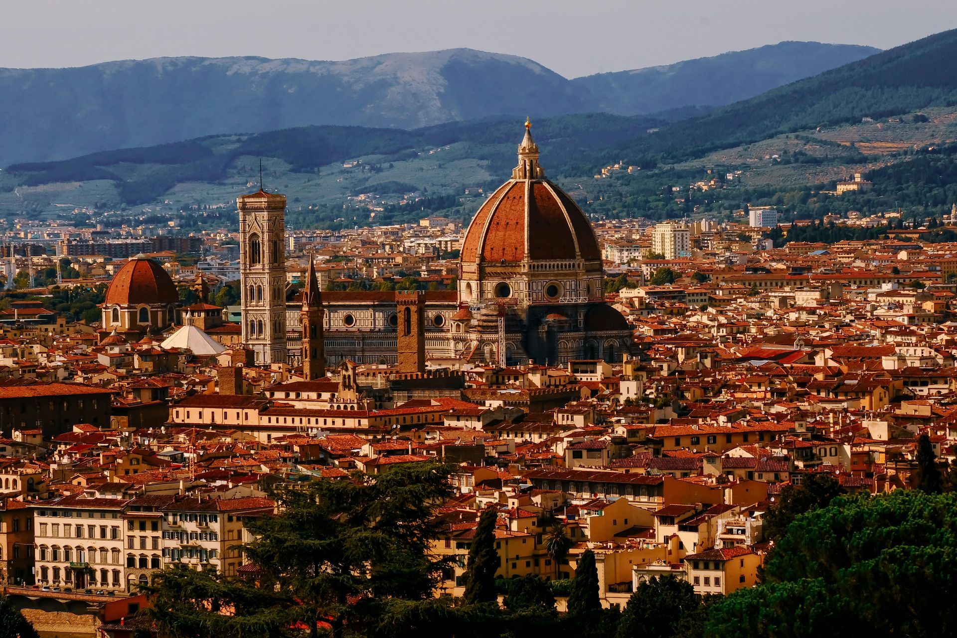 An aerial view of Florence, Italy with mountains in the background.