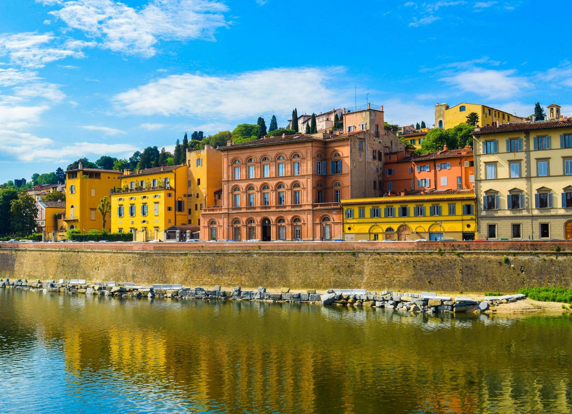 A row of buildings next to a body of water in Florence, Italy.