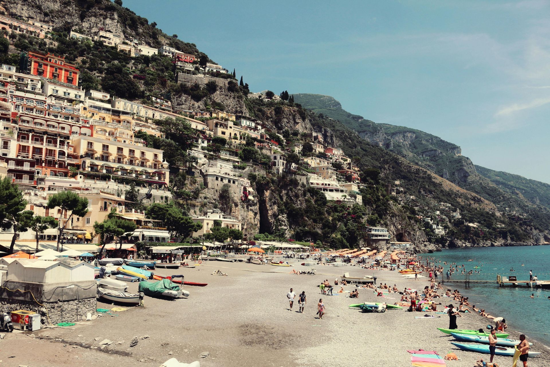 A beach with a lot of people and boats on it in the Amalfi Coast, Italy. 