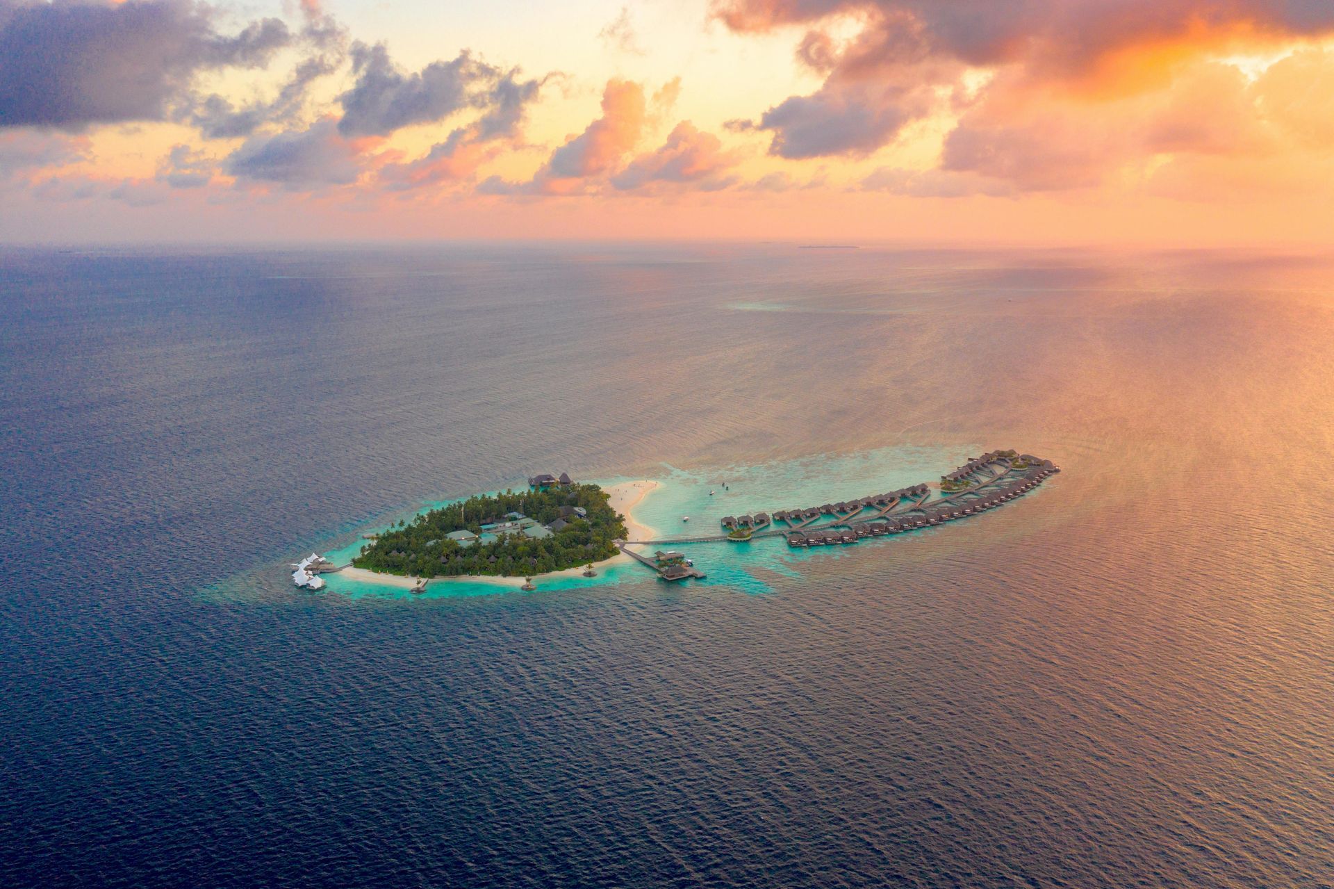 An aerial view of a small island in the middle of the ocean at sunset in the Caribbean.