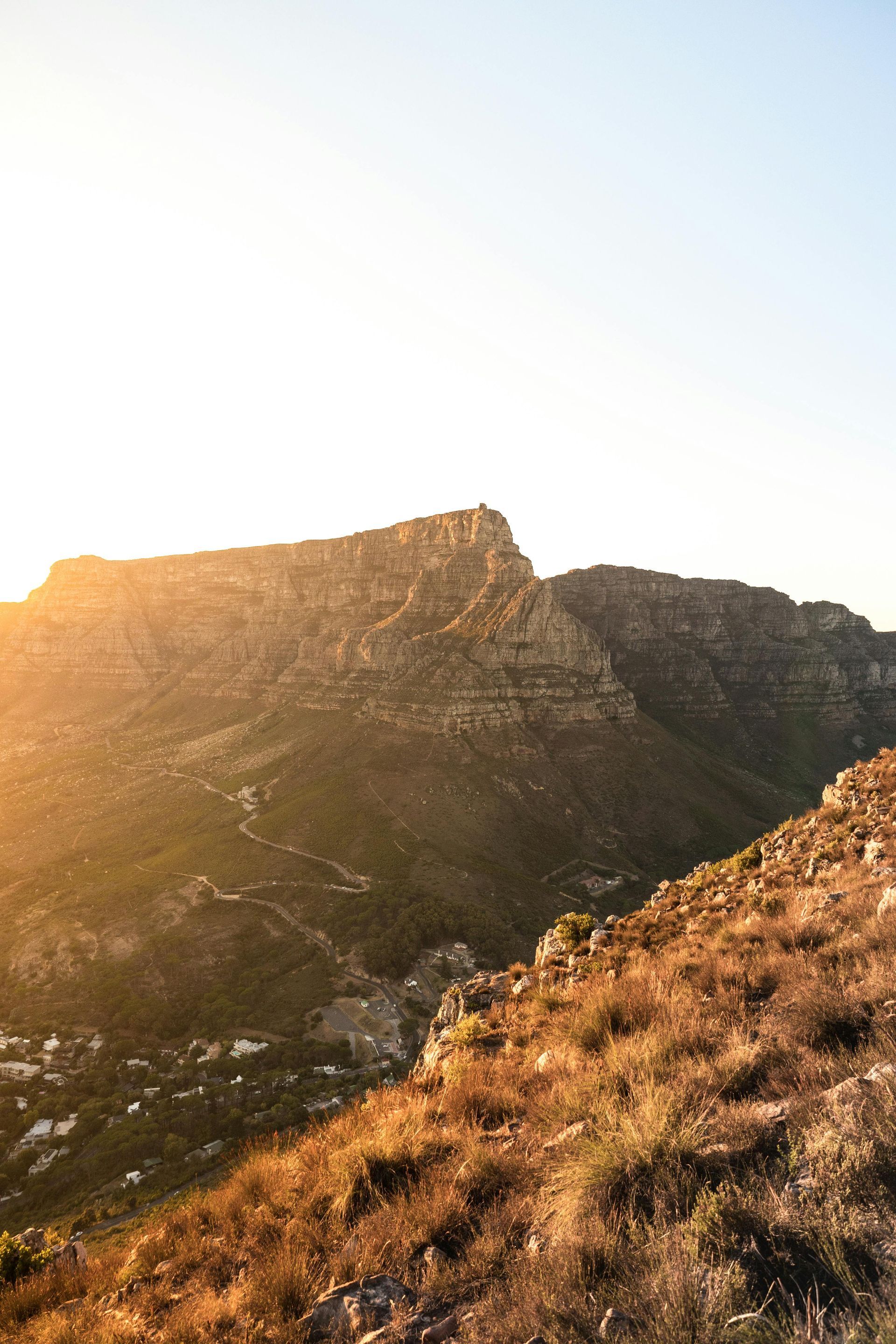 The sun is shining on a mountain covered in grass in South Africa.