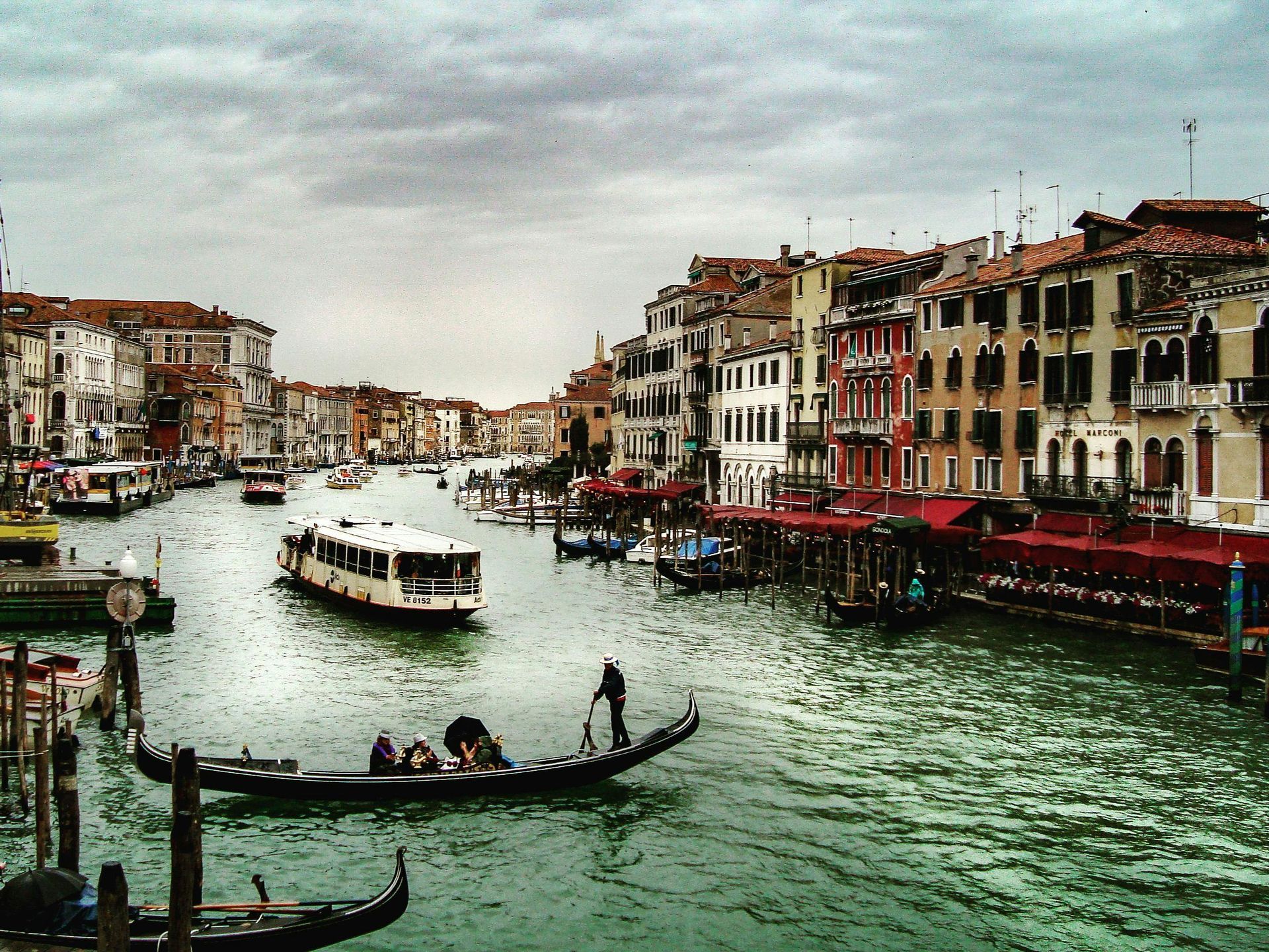 A boat is going down a canal with buildings in the background in Venice, Italy.