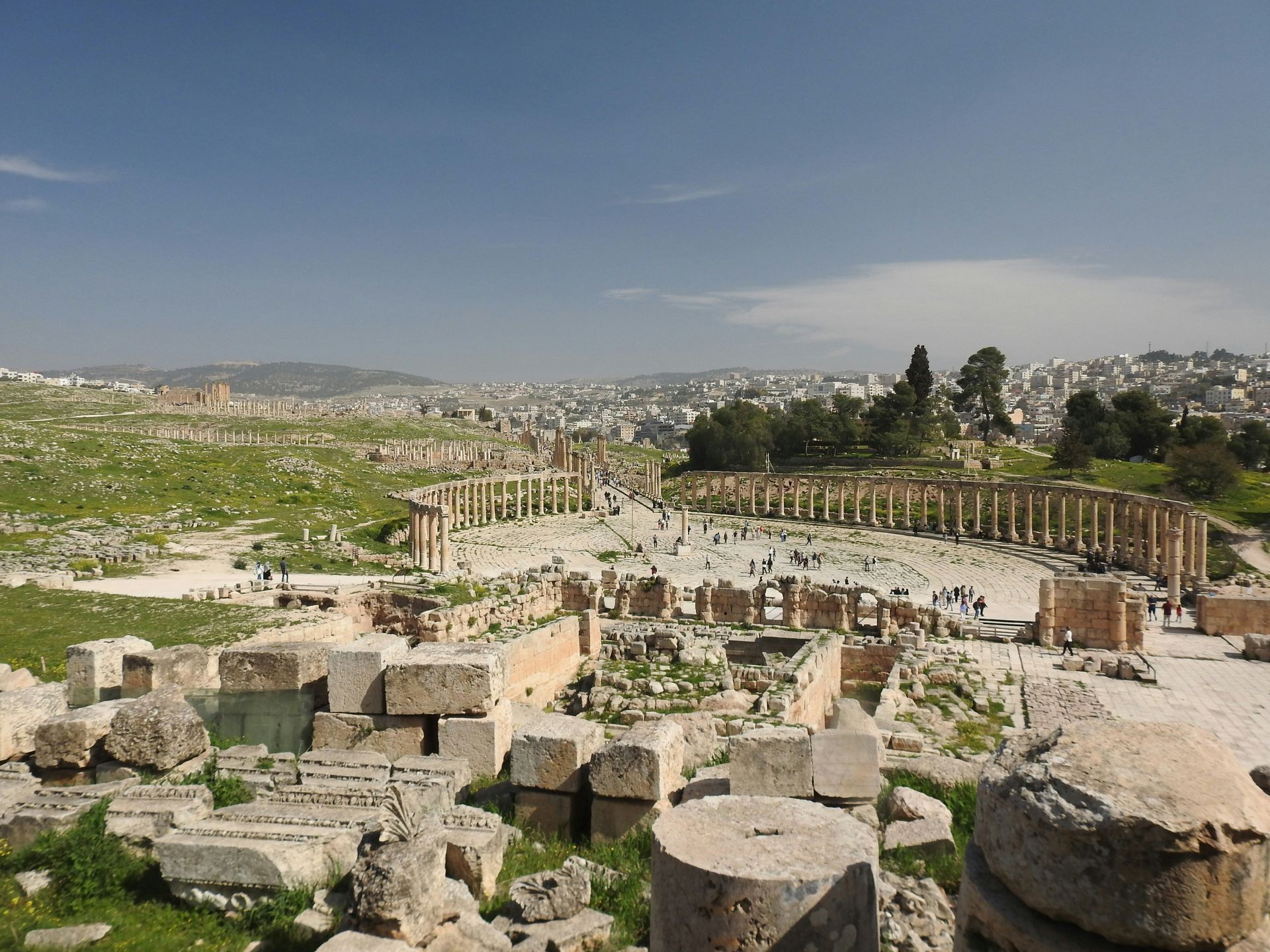 Ruins of an ancient city with partial columns and stonework, overlooking Jerash, Jordan.