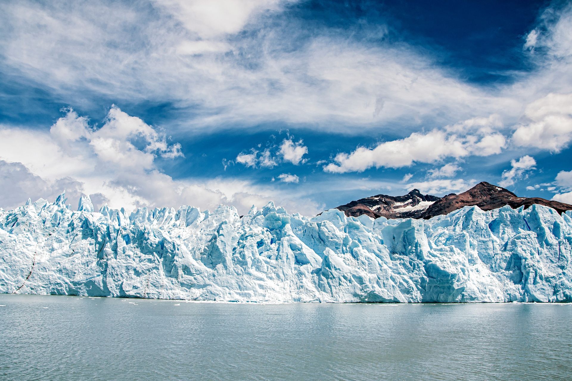 Glacier with blue ice and mountains in the background at Parque Nacional Los Glaciares in El Calafate, Argentina.
