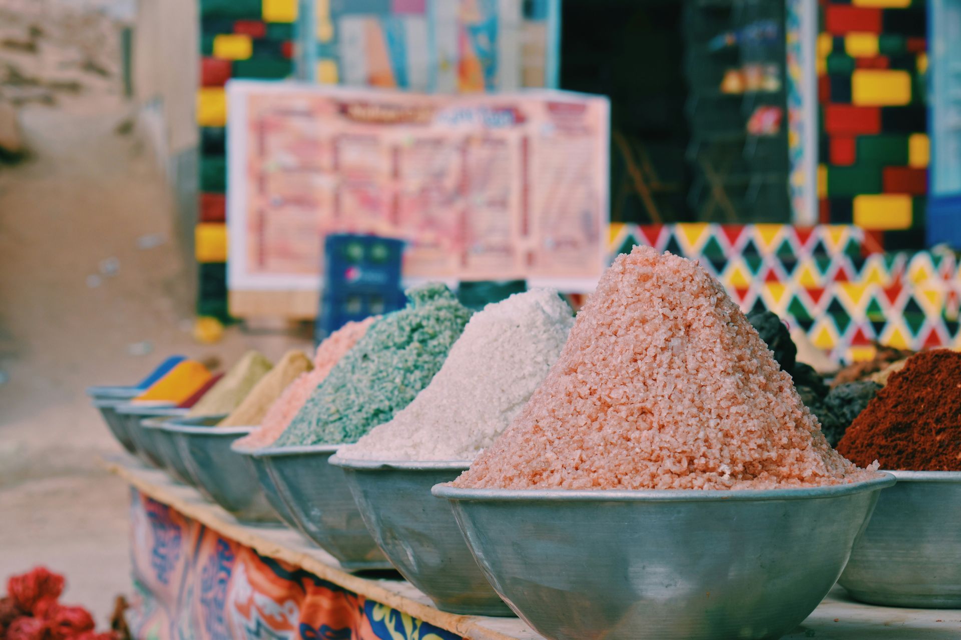 A row of bowls filled with different types of spices on a table in Aswan, Egypt.