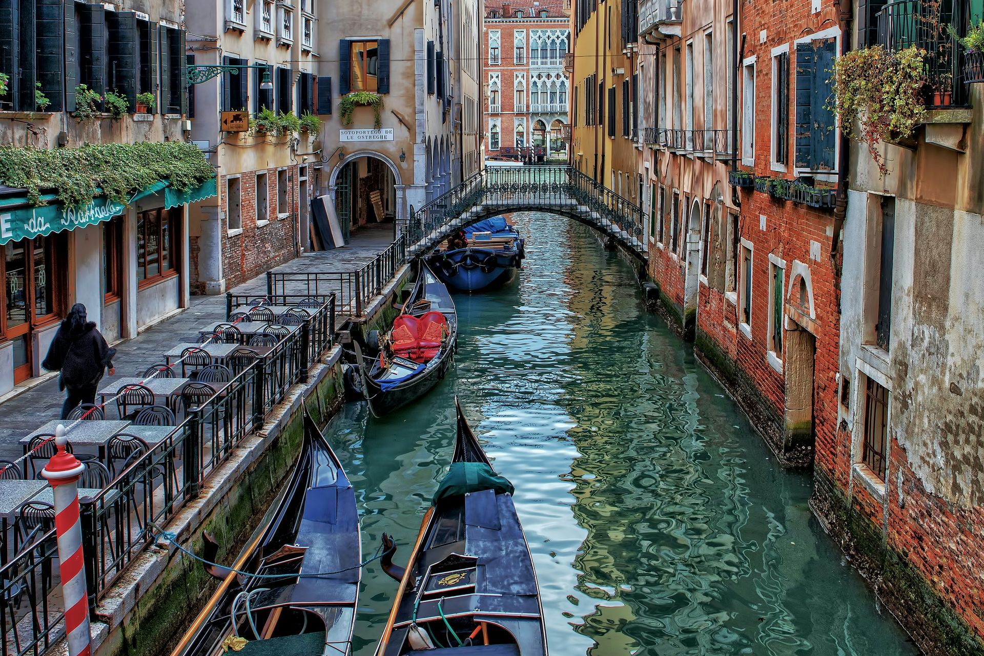 A couple of gondolas are floating down a canal in Venice.