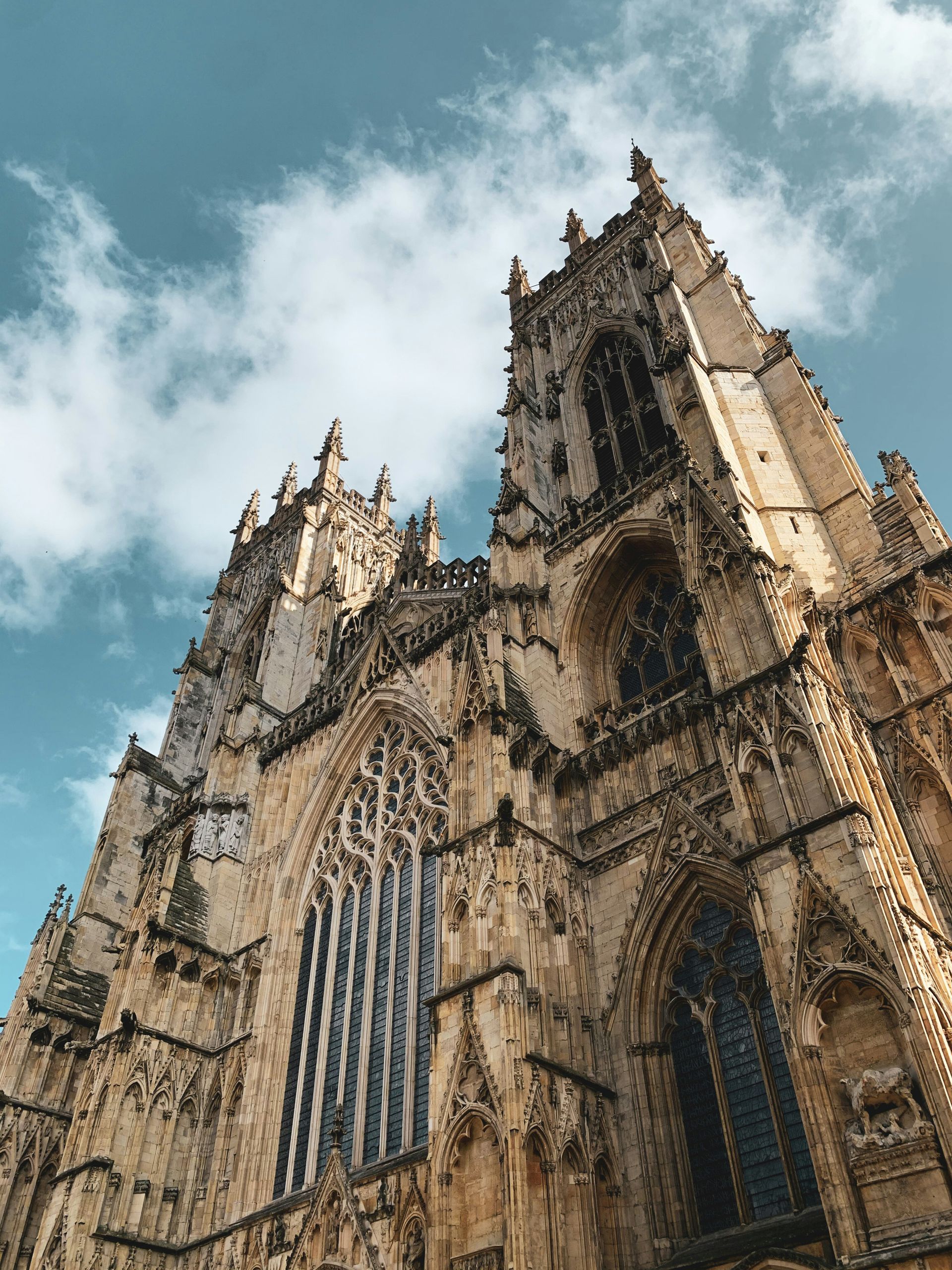 York Minster cathedral towers against a cloudy sky. Detailed stone architecture.