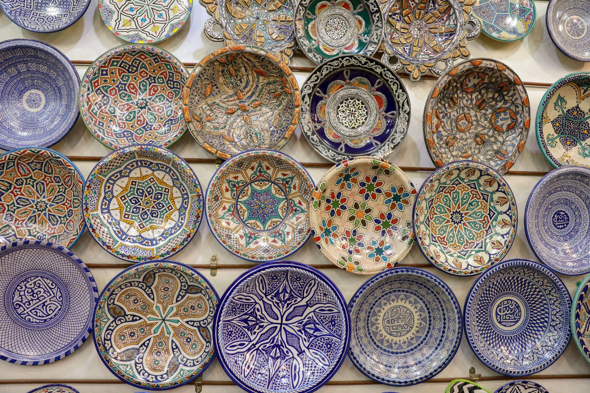 A wall full of plates with different designs on them in Fes, Morocco.