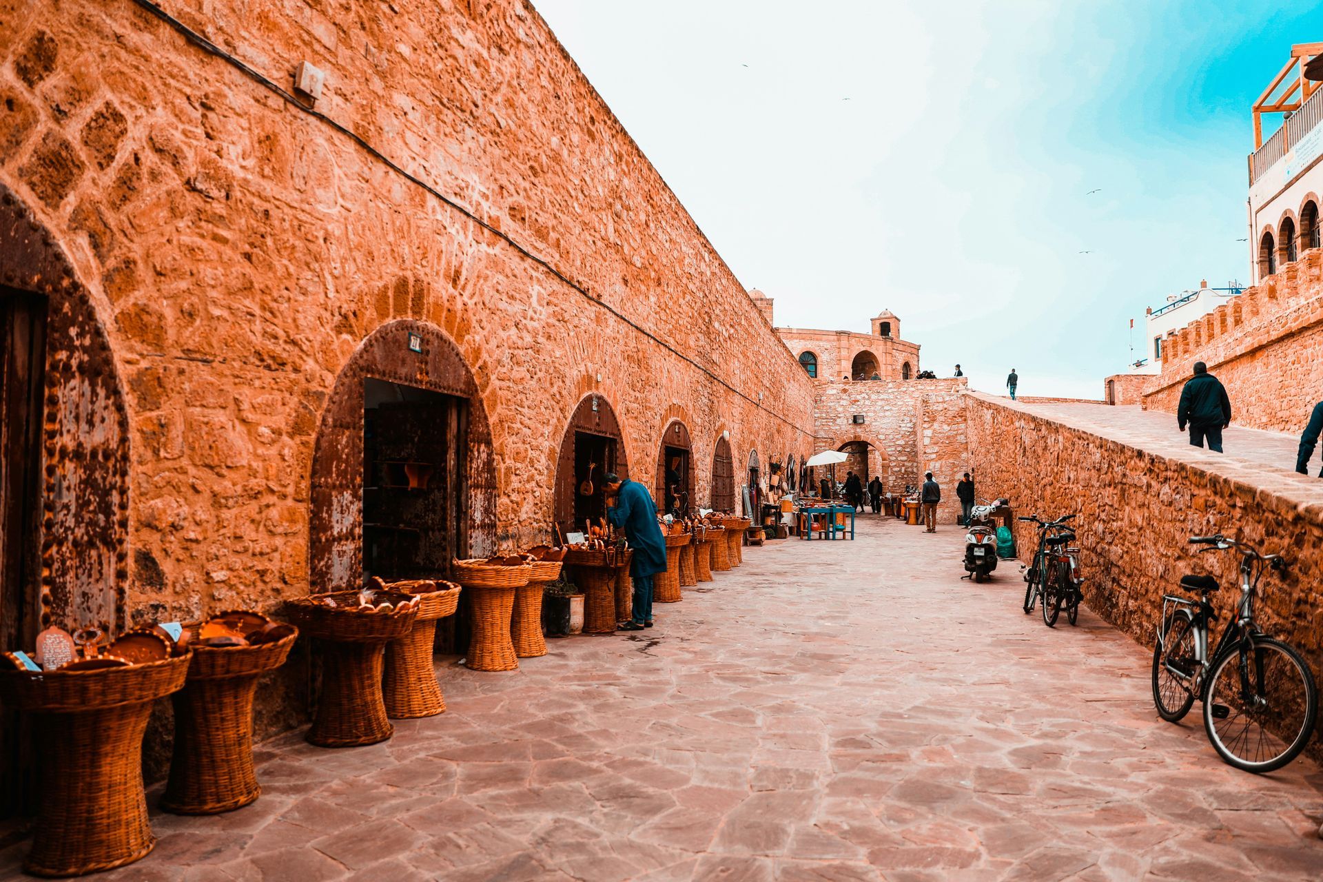 A group of people are standing in front of a stone building in Essaouira, Morocco.