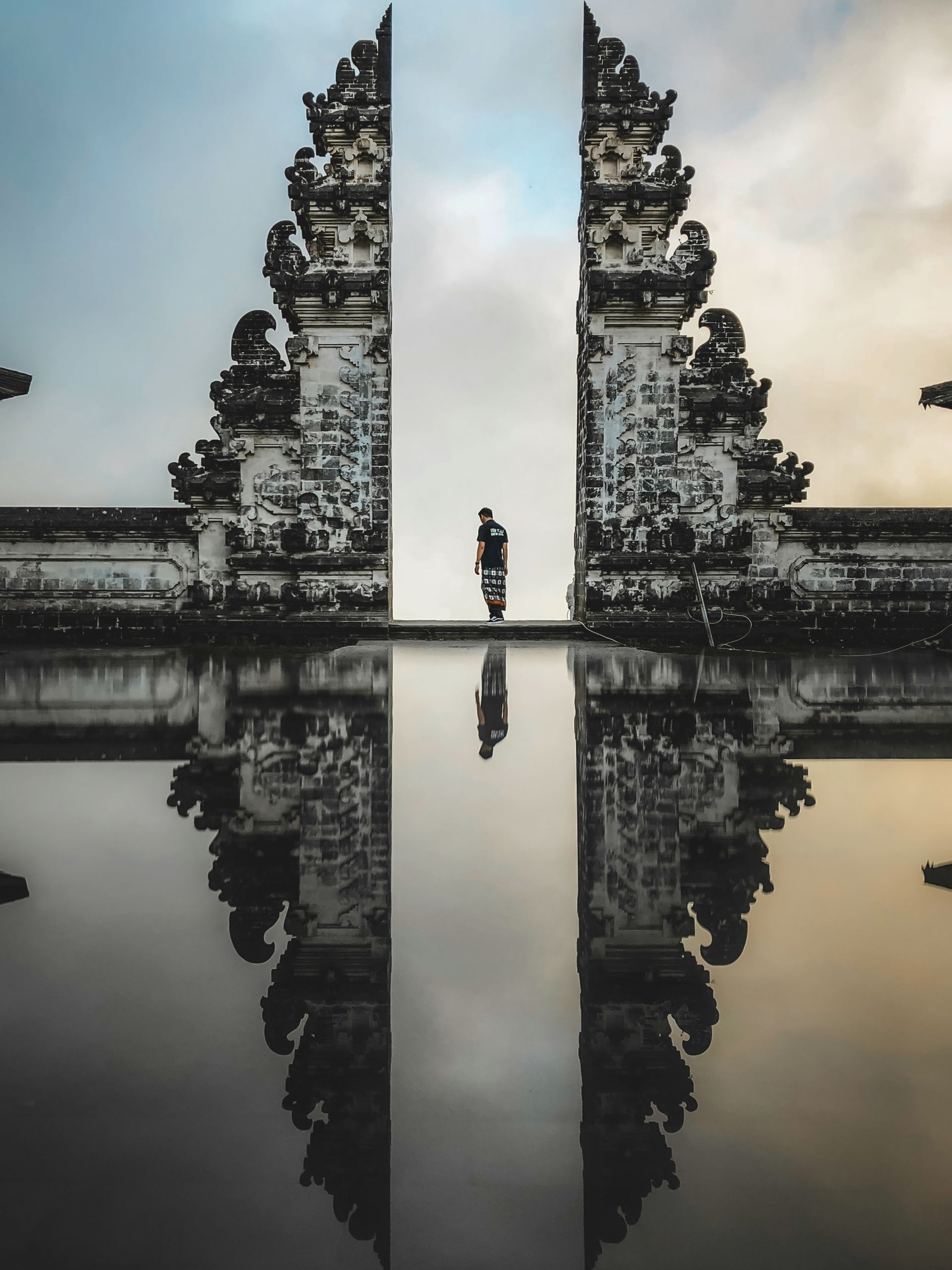 The Lempuyang Temple is reflected in the water of a lake in Bali.