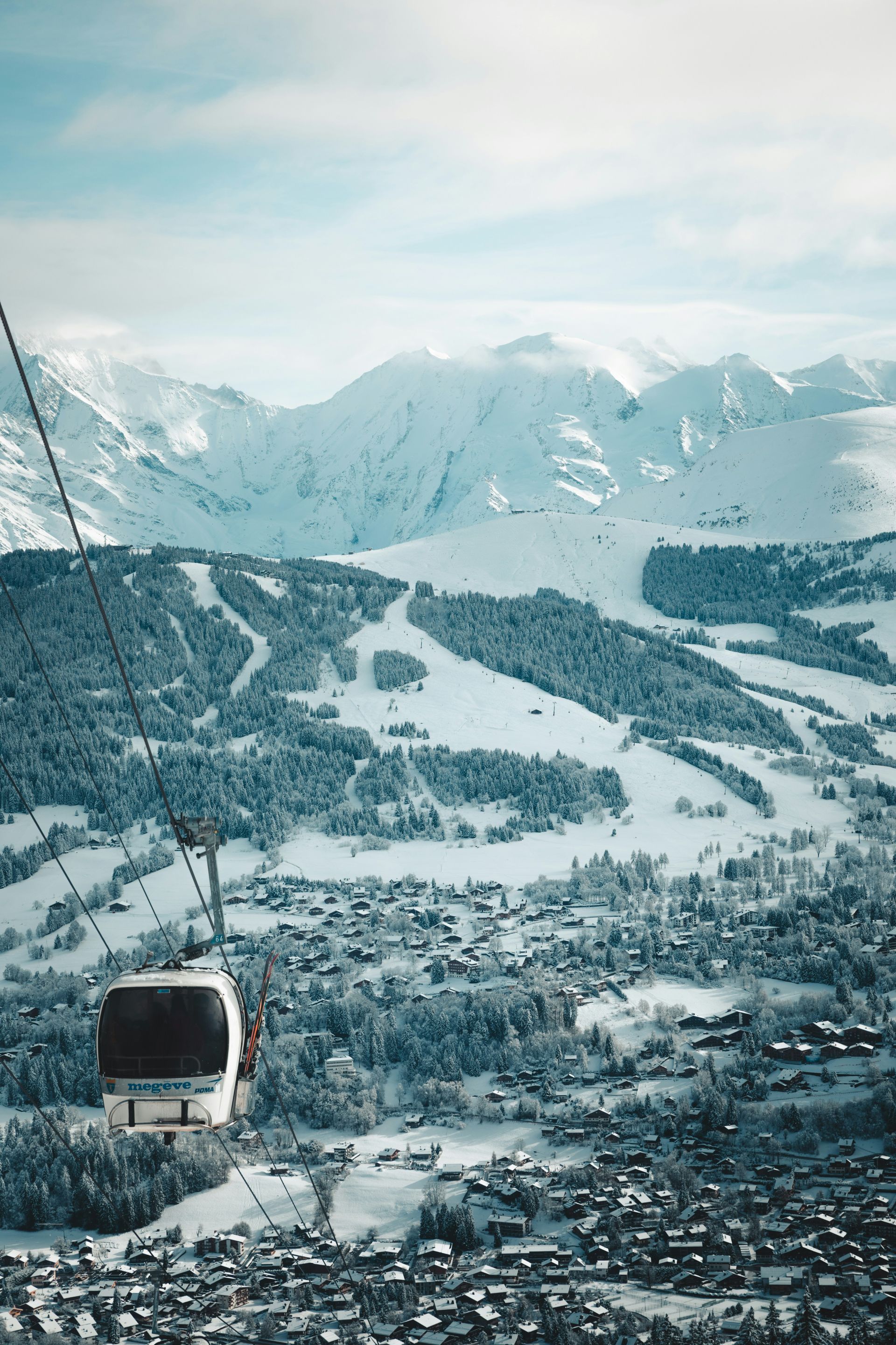A ski lift is going down a snow covered mountain in Megève, France.