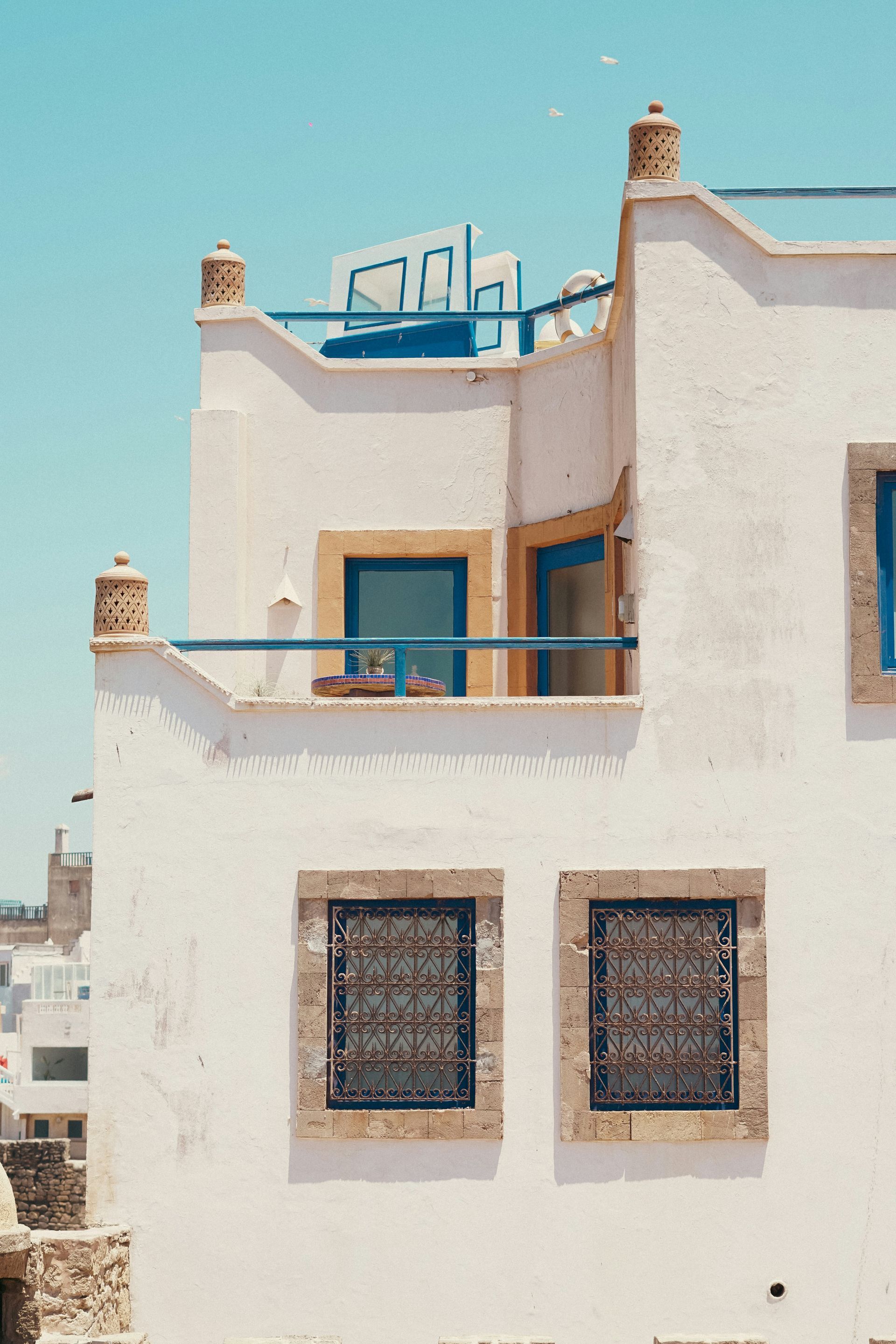 A white building with a balcony on the top of it in Essaouira, Morocco.