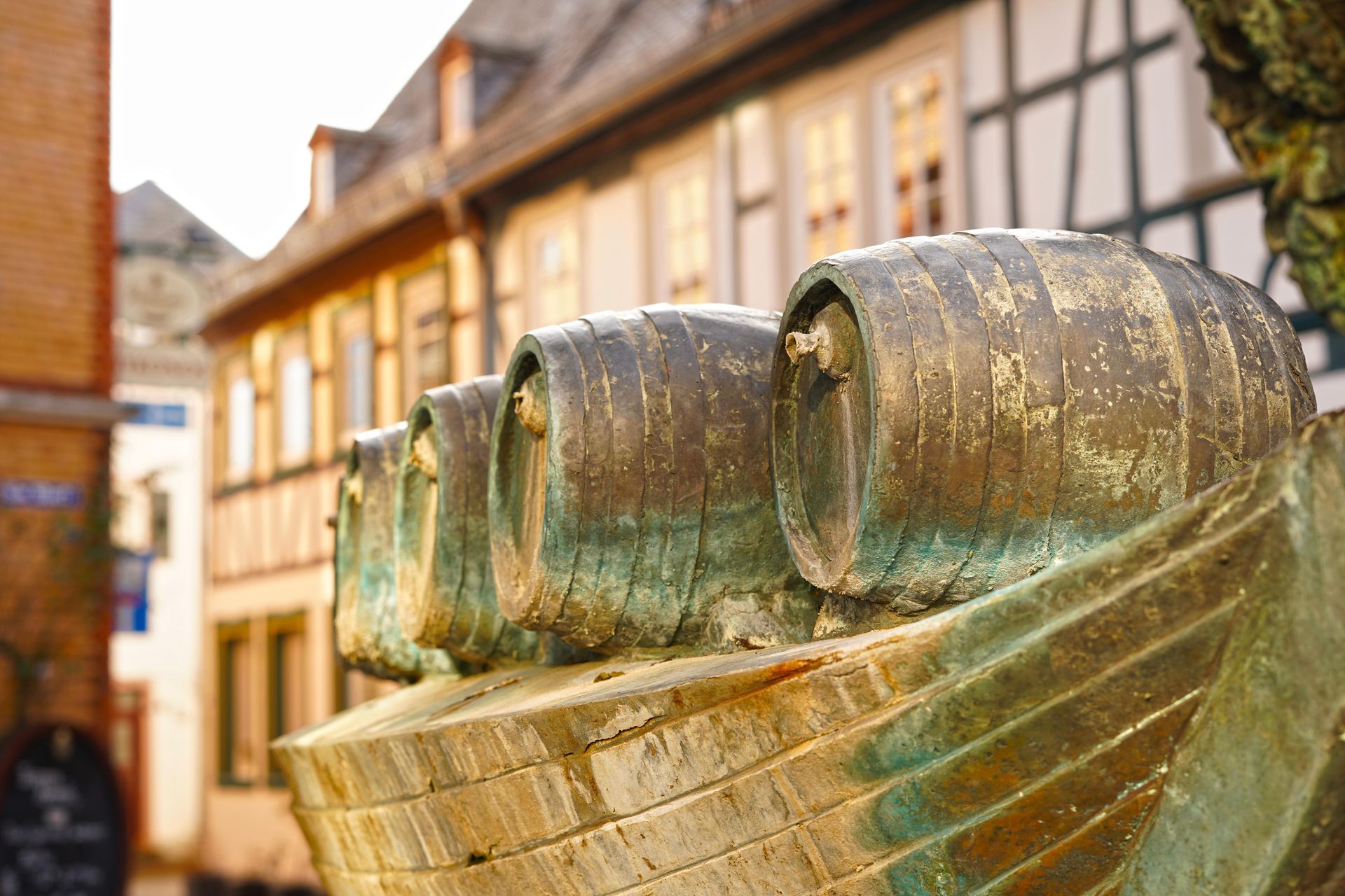 A statue of a boat filled with barrels in front of a building in Eltville, Germany.