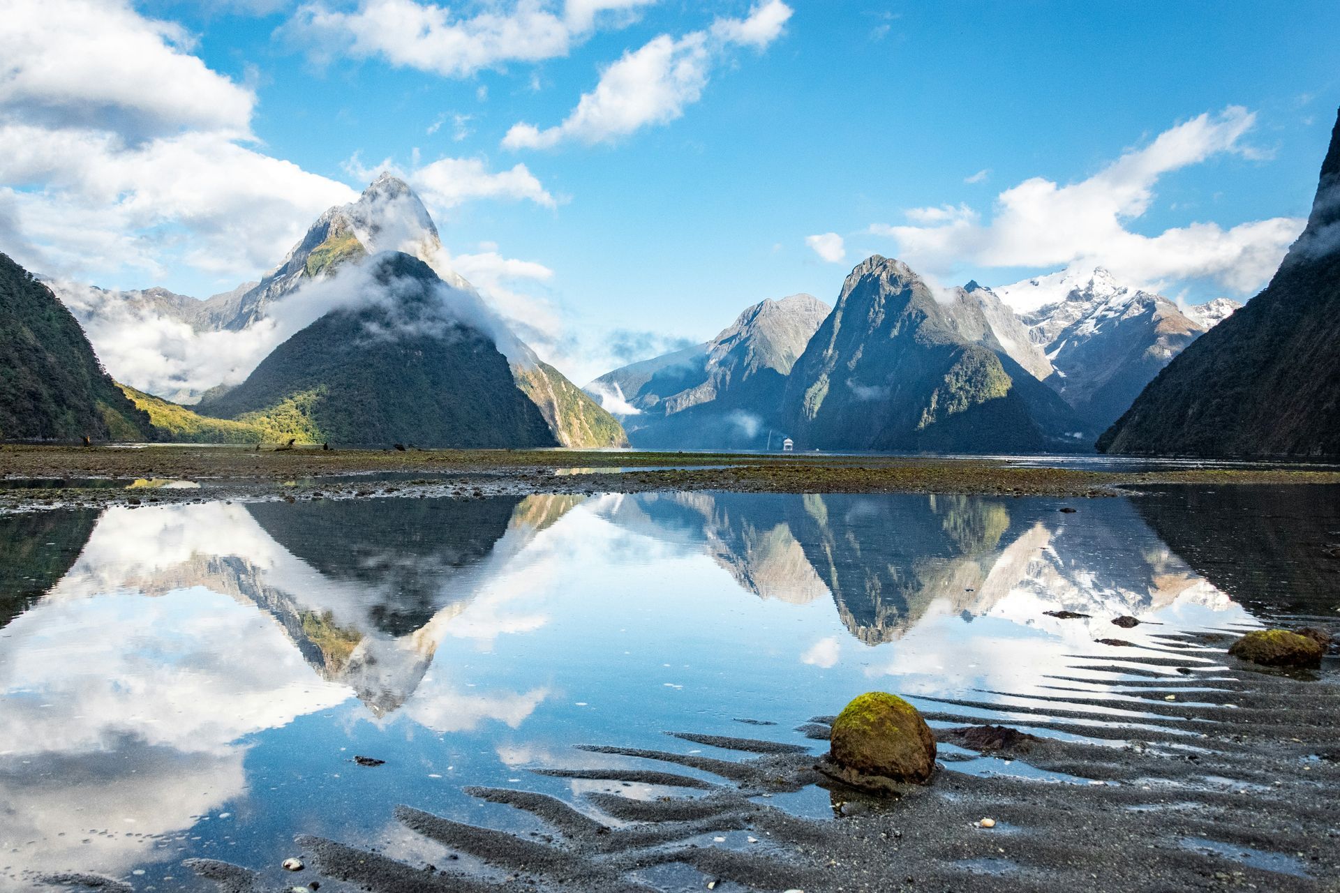 The Milford Sound with mountains reflected in the water in Fiordland National Park, New Zealand.