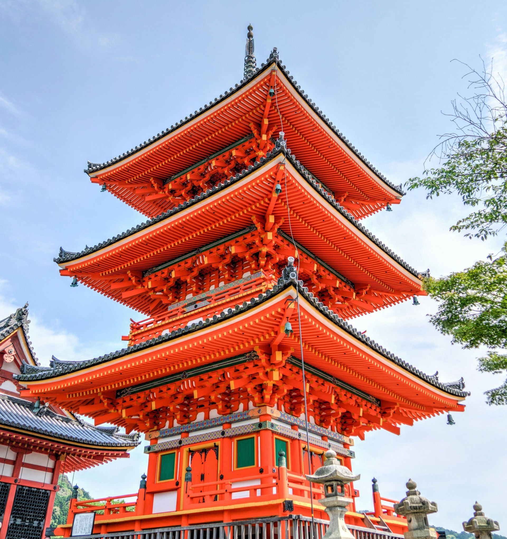 A very tall red pagoda temple with a blue sky in the background in Japan