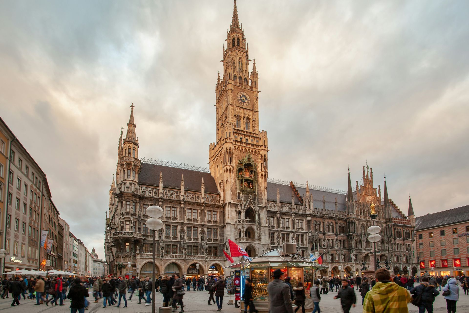 New Town Hall in Munich, Germany, with a tall clock tower, surrounded by people in a public square.