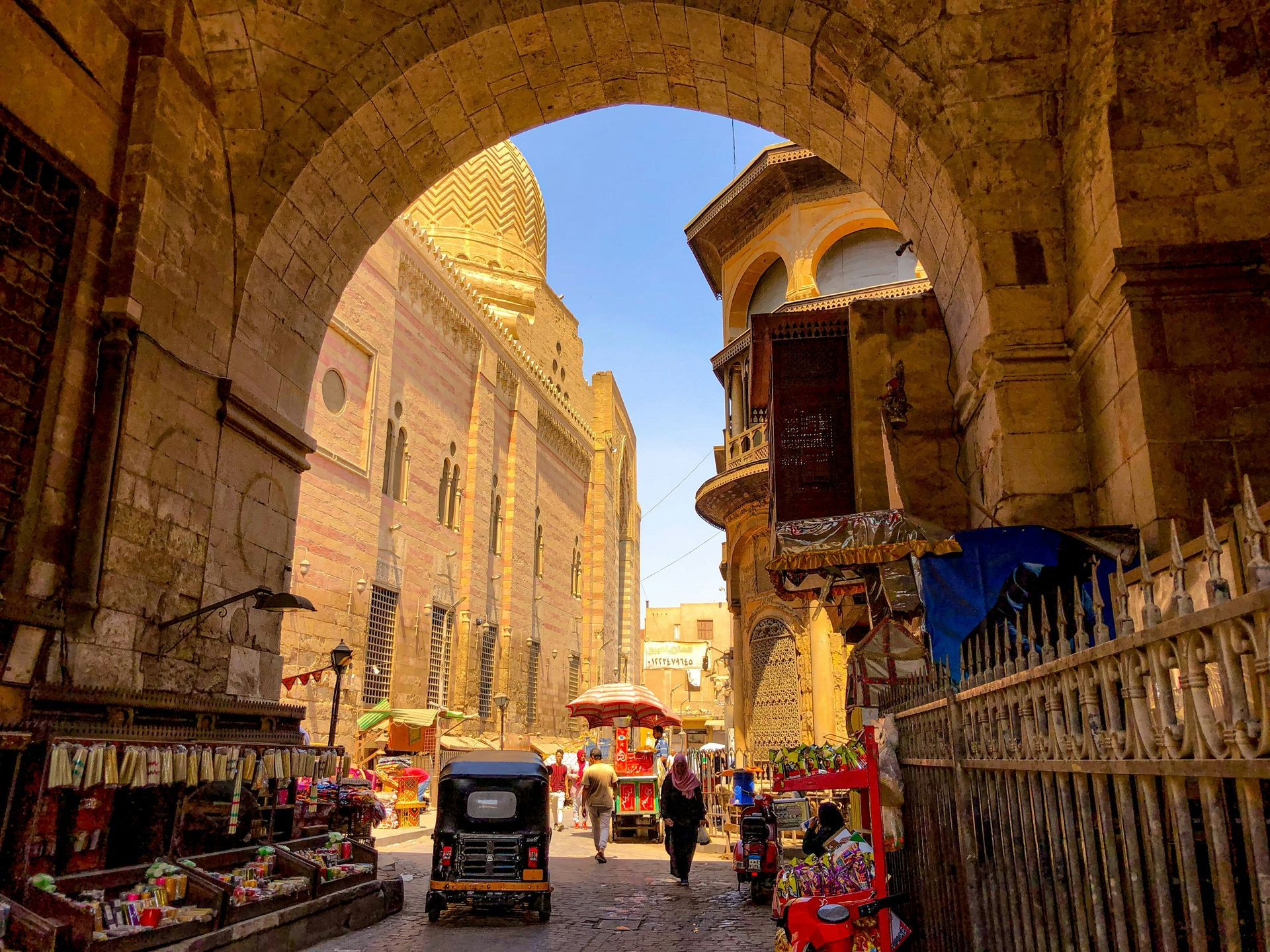 A car is driving through an archway in a narrow street in Cairo, Egypt.