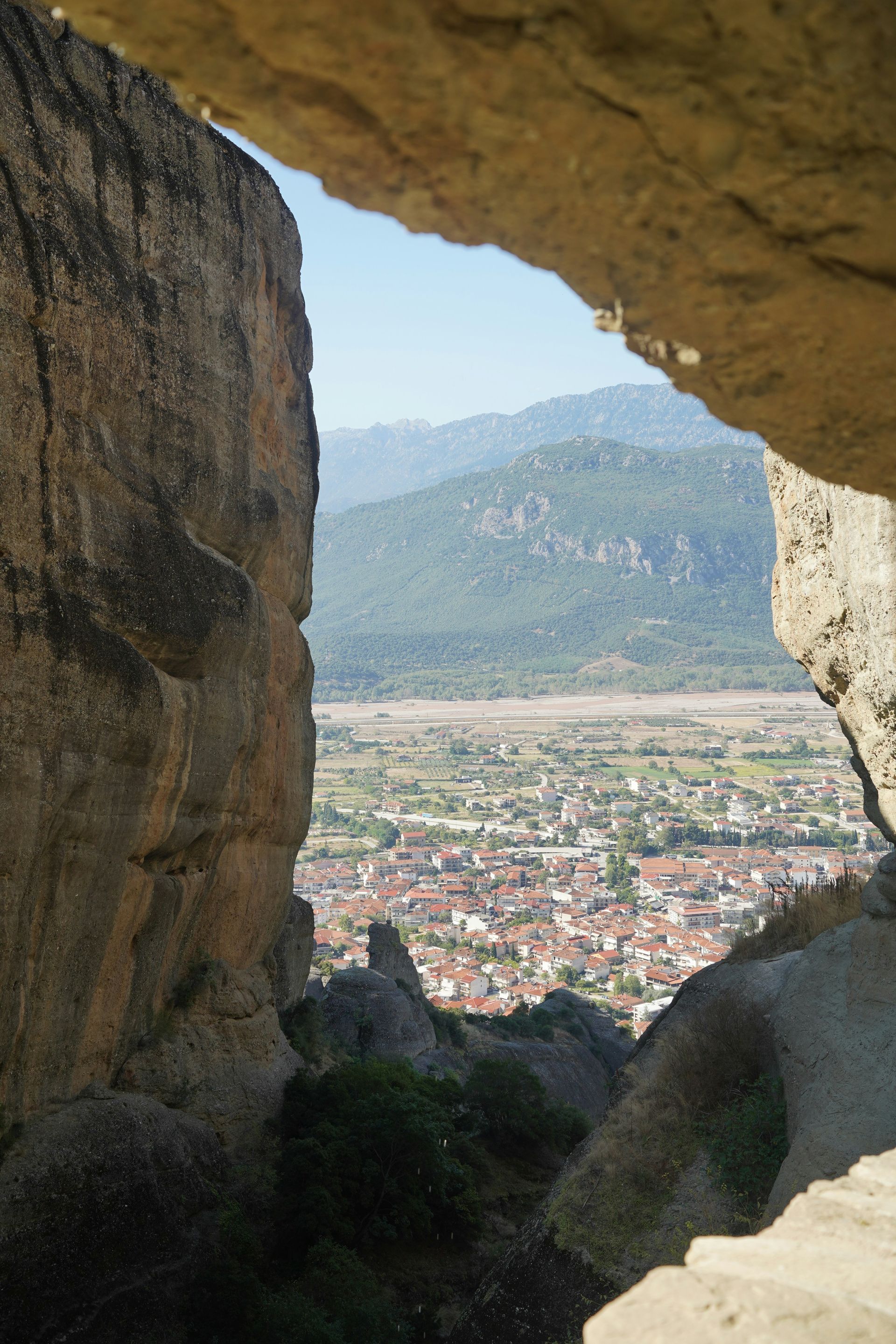 A view of Kalabaka, Greece from a cave with mountains in the background