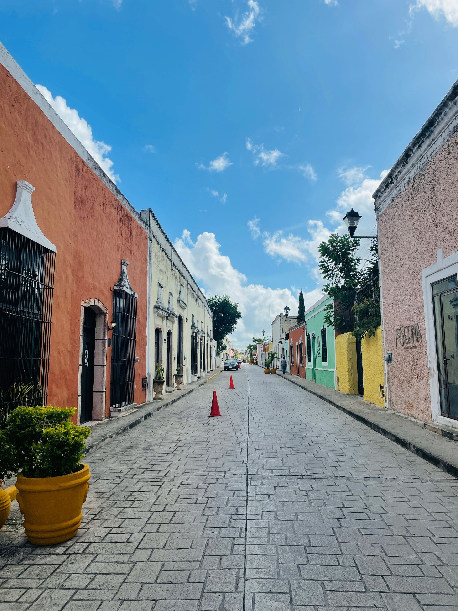 Cobblestone street lined with colorful buildings in Valladolid, Mexico.
