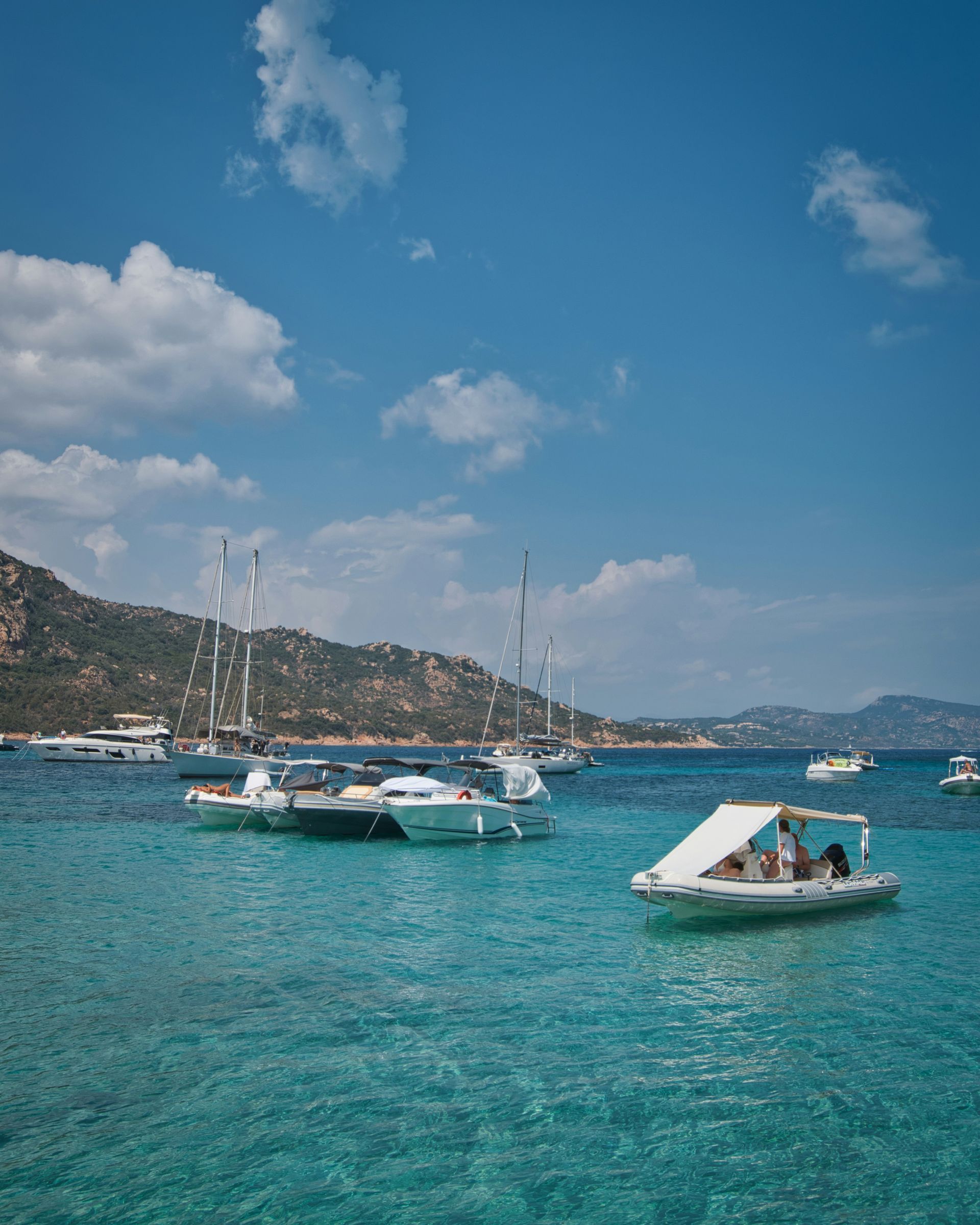 A group of boats are floating on top of a body of water in Corsica, France.