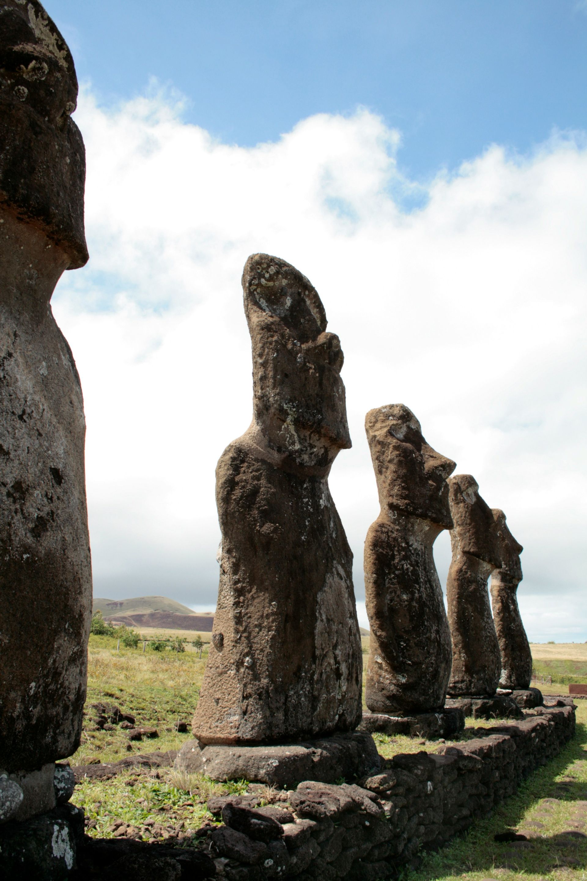 Moai statues on Easter Island, weathered stone figures against a blue sky.