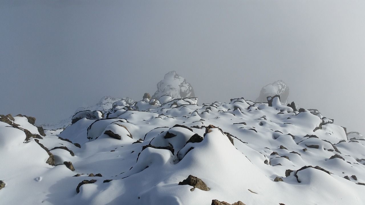 A mountain covered in snow and rocks on a foggy day in Switzerland.