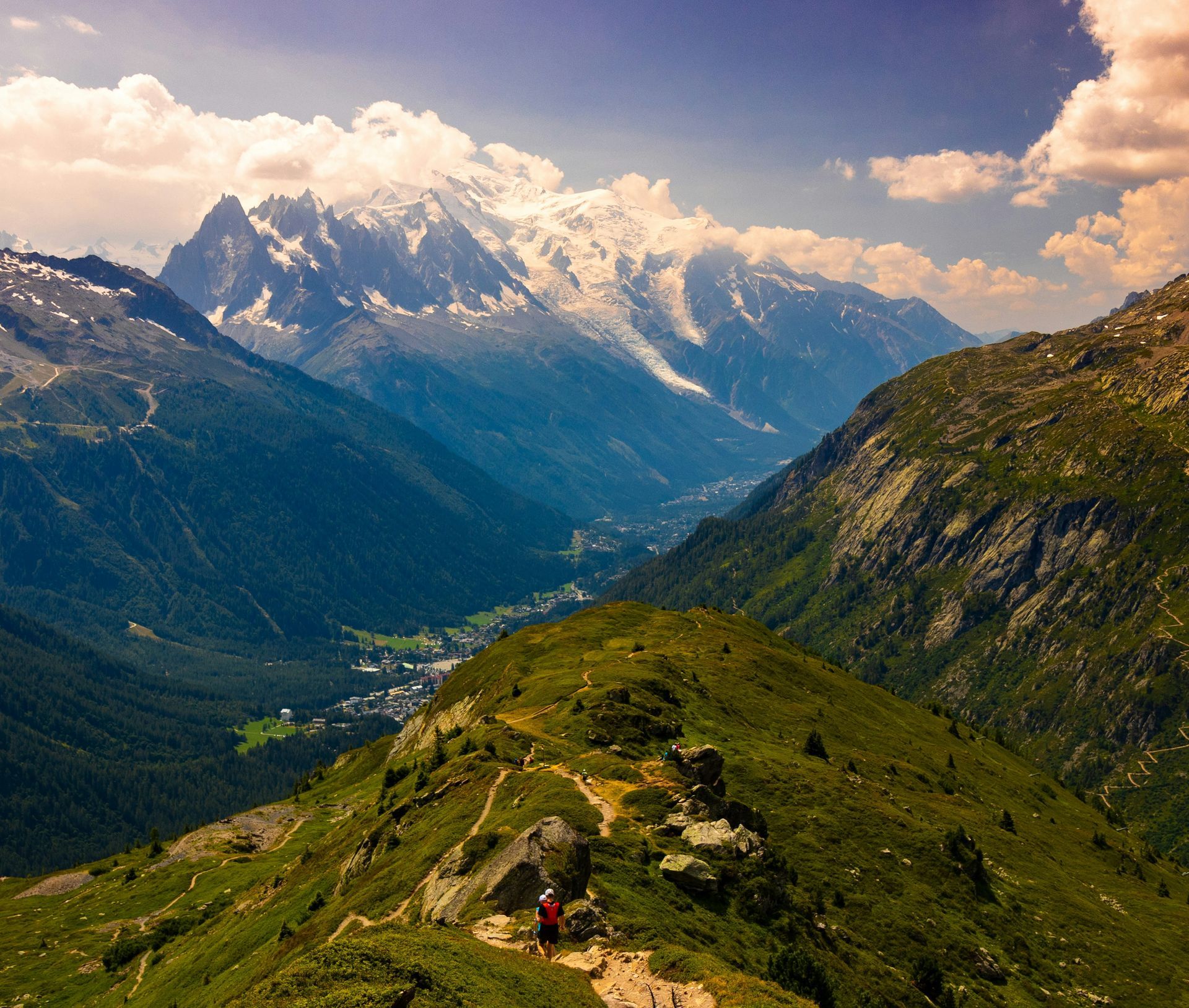 A person is standing on top of a grassy hill in the French Alps in Chamonix, France.