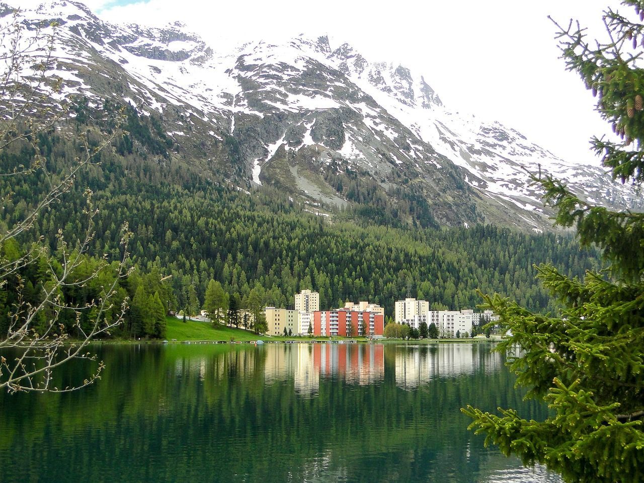 A lake with mountains in the background and trees in the foreground in Switzerland.