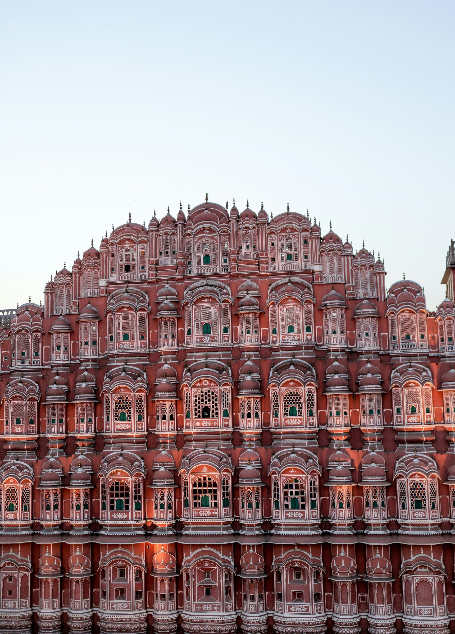 Hawa Mahal, Jaipur, India: Red and white sandstone facade with many small windows against a pale sky.