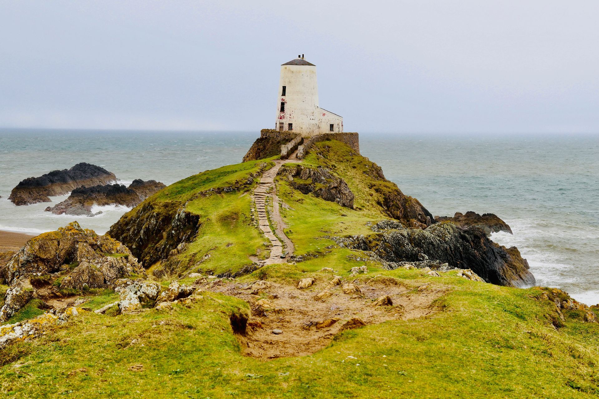 The path leads to the South Stack Lighthouse on a rocky islet surrounded by sea in Anglesey, Wales