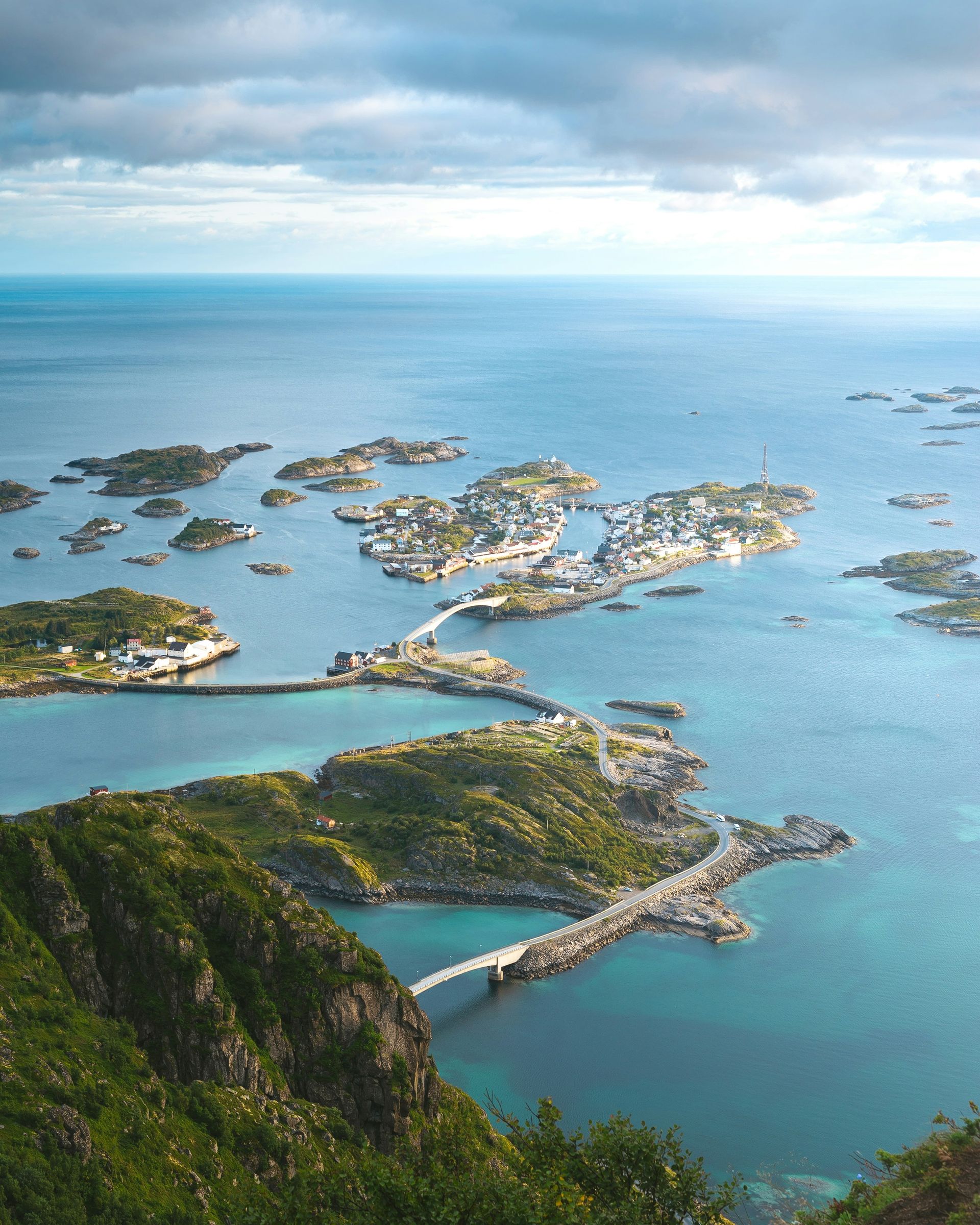 The Archipelago of Lofoten, Norway, is connected by bridges. Blue ocean, green hills, and scattered islands.