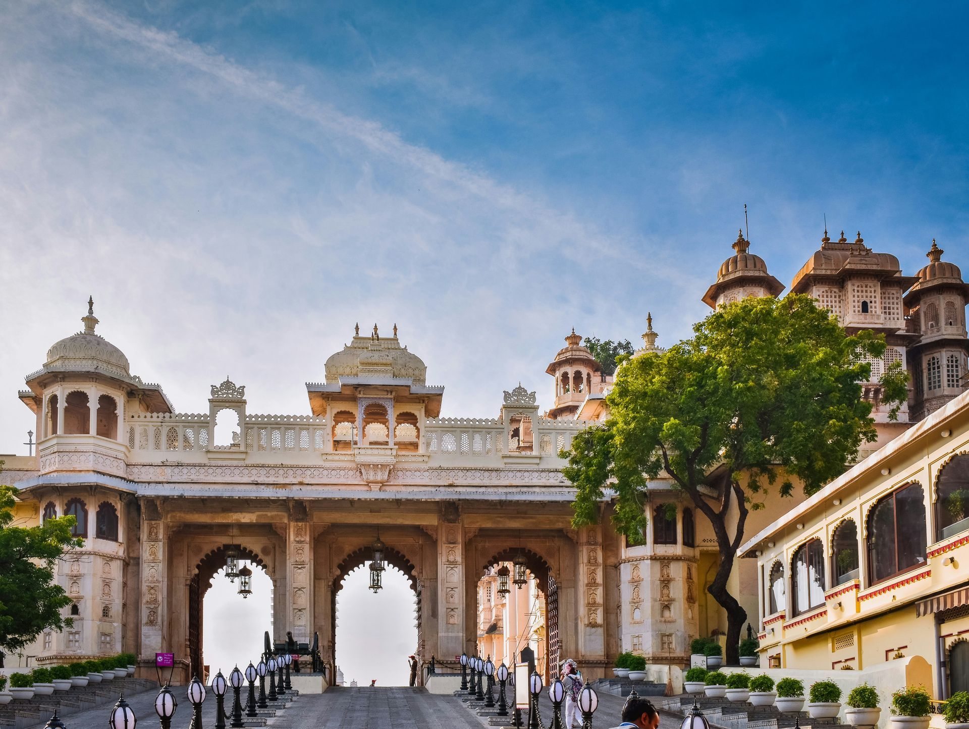 An aerial view of a large building with Udaipur, India, in the background.